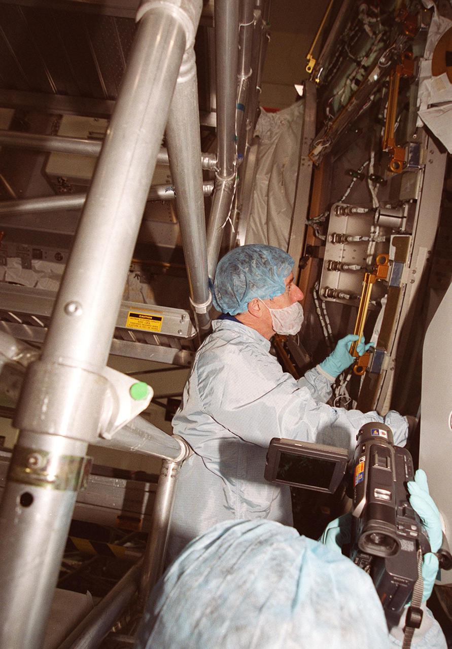 KENNEDY SPACE CENTER, FLA. -- At the Space Station Processing Facility, STS-104 Mission Specialist James F. Reilly II checks out a piece of equipment. The crew is at KSC to take part in Crew Equipment Interface Test activities. Reilly will perform three spacewalks during the mission, which will carry the Joint Airlock Module to the International Space Station. The U.S.-made module will allow astronauts and cosmonauts in residence on the Station to perform future spacewalks without the presence of a Space Shuttle. The module, which comprises a crew lock and an equipment lock, will be connected to the starboard (right) side of Node 1 Unity. Atlantis will also carry oxygen and nitrogen storage tanks, vital to operation of the Joint Airlock, on a Spacelab Logistics Double Pallet in the payload bay. The tanks, to be installed on the perimeter of the Joint Module during the mission’s spacewalks, will support future spacewalk operations and experiments plus agument the resupply system for the Station’s Service Module