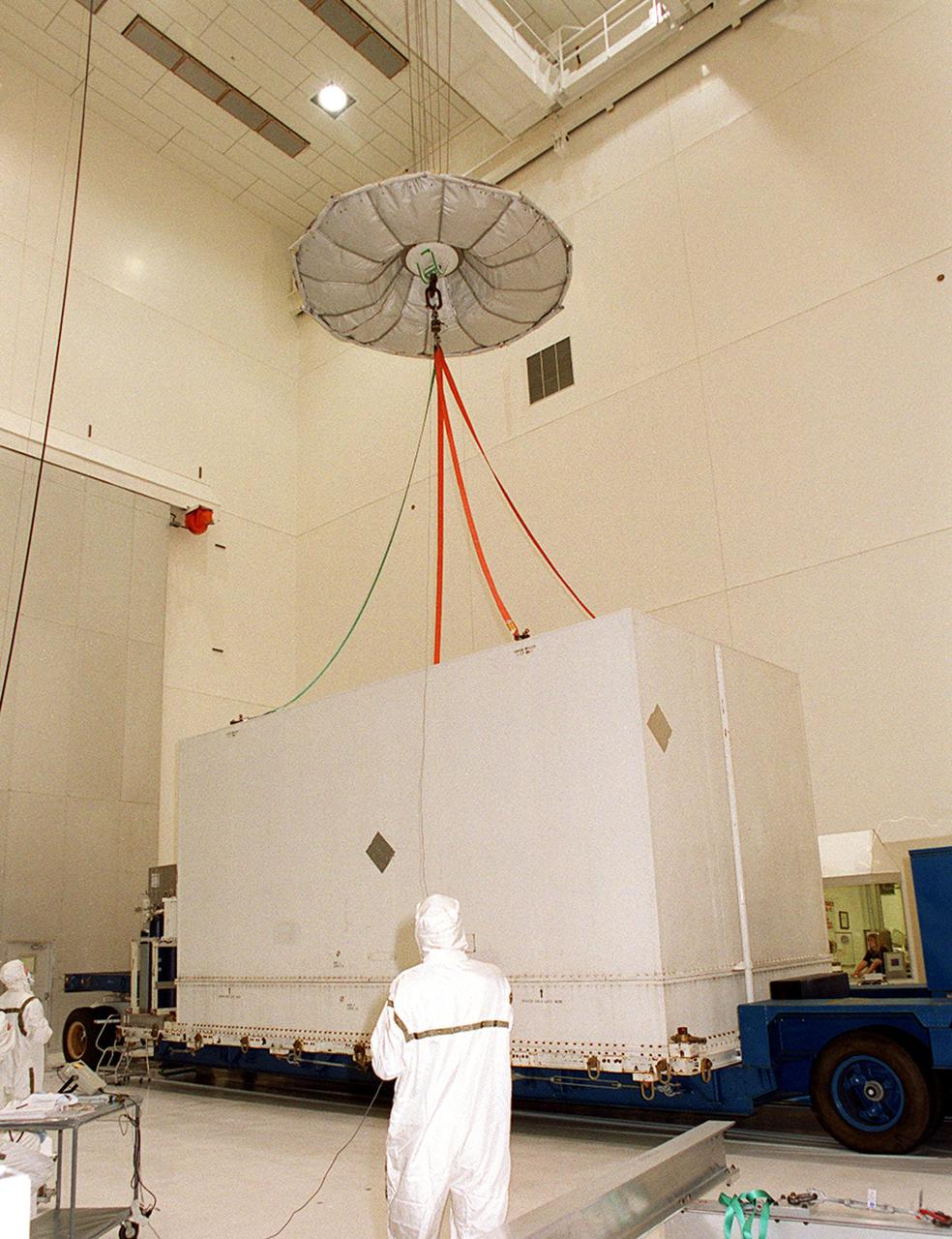 KENNEDY SPACE CENTER, FLA. -- Inside the Spacecraft Assembly and Encapsulation Facility 2, an overhead crane is attached to the container surrounding the Microwave Anisotropy Probe (MAP) satellite. MAP will undergo testing in the SAEF-2 before its scheduled launch June 30 from Cape Canaveral Air Force Station on a Delta II rocket into a lunar-assisted trajectory to the Sun-Earth for a 27-month mission (3 months transit, 24 months observing). The MAP instrument consists of a set of passively cooled microwave radiometers with 1.4x 1.6-meter diameter primary reflectors to provide the desired angular resolution. MAP measures small fluctuations in the temperature of the cosmic microwave background radiation to an accuracy of one millionth of a degree. These measurements should reveal the size, matter content, age, geometry and fate of the universe. They will also reveal the primordial structure that grew to form galaxies and will test ideas about the origins of these primordial structures. The MAP instrument will be continuously shaded from the Sun, Earth, and Moon by the spacecraft. It is a product of Goddard Space Flight Center in partnership with Princeton University