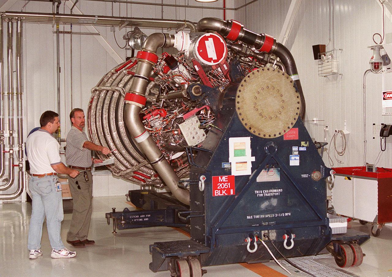 KENNEDY SPACE CENTER, FLA. -- Mike Cosgrove (left) and Bob Petrie (right), both with Boeing_Rocketdyne, look over the upgraded Space Shuttle main engine (block 2 engine) as it sits in the Space Shuttle Main Engine Processing Facility. The new engine will be installed for its first flight on the orbiter Atlantis, on mission STS-104. The Block II Main Engine configuration is manufactured by Boeing Rocketdyne in Canoga Park, Calif., and includes a new Pratt and Whitney high-pressure fuel turbo pump. Engine improvements are managed by NASA’s Marshall Space Flight Center in Huntsville, Ala. Each Space Shuttle Main Engine is 14 feet (4.3 meters) long, weighs about 7,000 pounds (3,175 kilograms), and is 7.5 feet (2.3 meters) in diameter at the end of the nozzle
