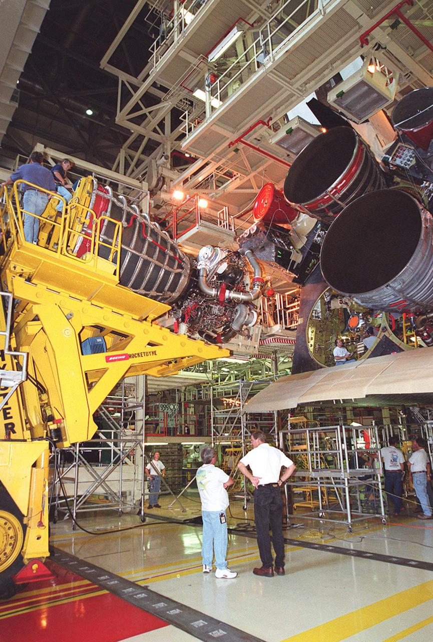 KENNEDY SPACE CENTER, FLA. -- In Orbiter Processing Facility bay 3, a new block 2 engine, at left, is moved into position for installation on Atlantis. The engine will have its first flight on mission STS-104, scheduled for launch June 14. The Block II Main Engine configuration is manufactured by Boeing Rocketdyne in Canoga Park, Calif., and includes a new Pratt and Whitney high-pressure fuel turbo pump. Engine improvements are managed by NASA’s Marshall Space Flight Center in Huntsville, Ala. Each Space Shuttle Main Engine is 14 feet (4.3 meters) long, weighs about 7,000 pounds (3,175 kilograms), and is 7.5 feet (2.3 meters) in diameter at the end of the nozzle