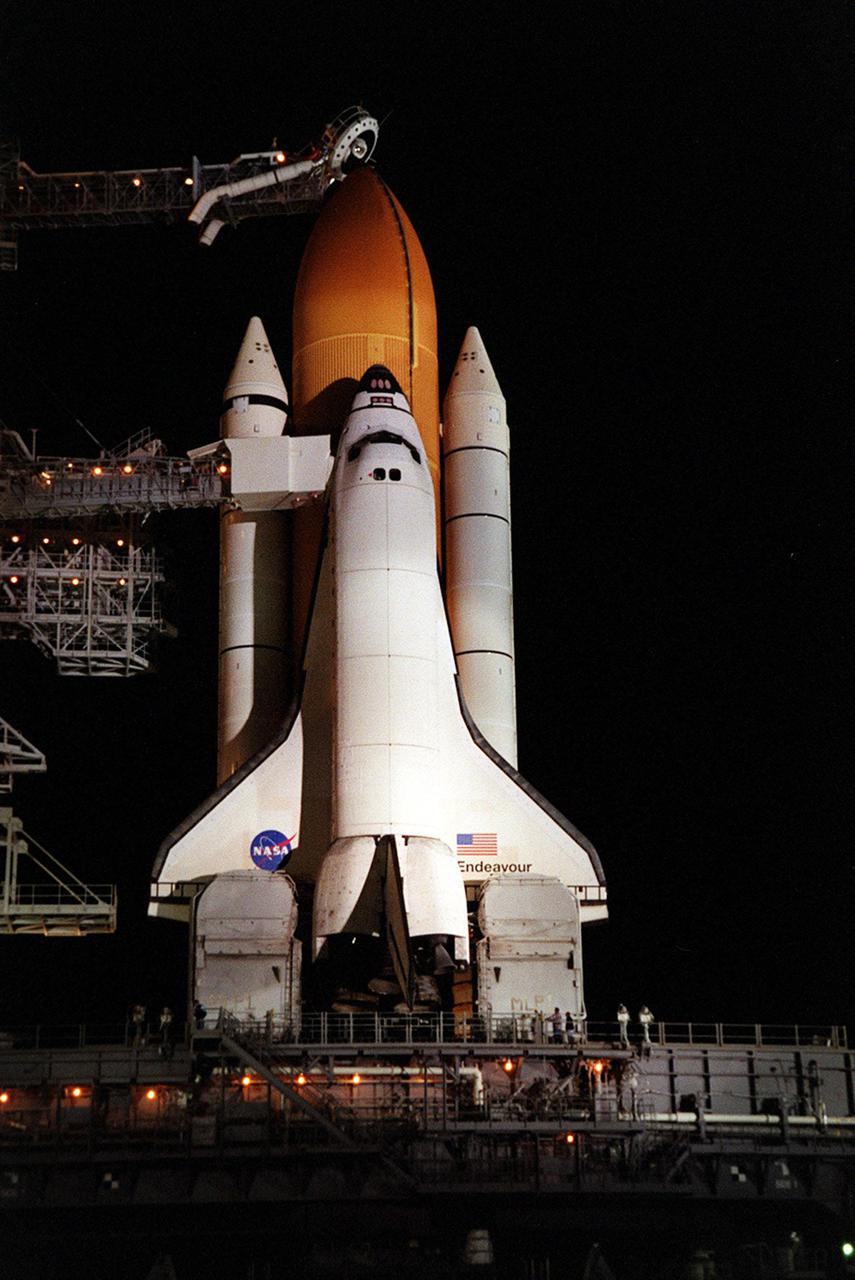 KENNEDY SPACE CENTER, Fla. -- Space Shuttle Endeavour is bathed in light as it waits on Launch Pad 39A. At the top of the external tank can be seen the “beanie cap,” a venting apparatus at the end of the Gaseous Oxygen Vent Arm. Stretching past the solid rocket booster to the orbiter is the Orbiter Access Arm with the White Room at the end. The White Room provides a controlled environment for entry into the orbiter. Endeavour is expected to lift off on mission STS-100 on April 19, carrying the Multi-Purpose Logistics Module Raffaello and the Canadian robotic arm, SSRMS, with a crew of seven to the International Space Station