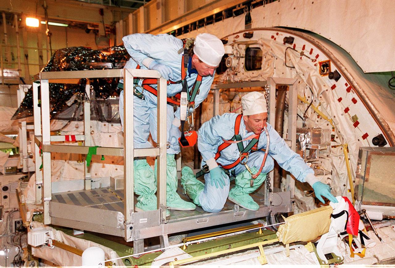 KENNEDY SPACE CENTER, FLA. -- In the Orbiter Processing Facility, STS-104 Mission Specialist Michael Gernhardt (left) and Pilot Charles Hobaugh (right) check out the slidewire used during extravehicular activities to keep the astronauts tethered to the orbiter. The STS-104 crew is at KSC to continue Crew Equipment Interface Test activities such as payload familiarization. The Joint Airlock Module is the primary payload on their mission, scheduled to launch no earlier than June 14, 2001, from Launch Pad 39B
