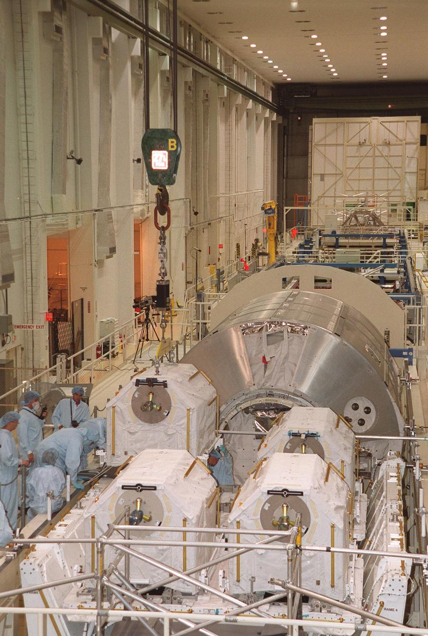 KENNEDY SPACE CENTER, FLA. -- In the Operations and Checkout Building, the last of four gas tanks is placed on the Spacelab Logistics Double Pallet. Part of the STS-104 payload, the storage tanks two gaseous oxygen and two gaseous nitrogen comprise the high pressure gas assembly that will be attached to the Joint Airlock Module during two spacewalks. The tanks will support future spacewalk operations from the Station and augment the Service Module gas resupply system