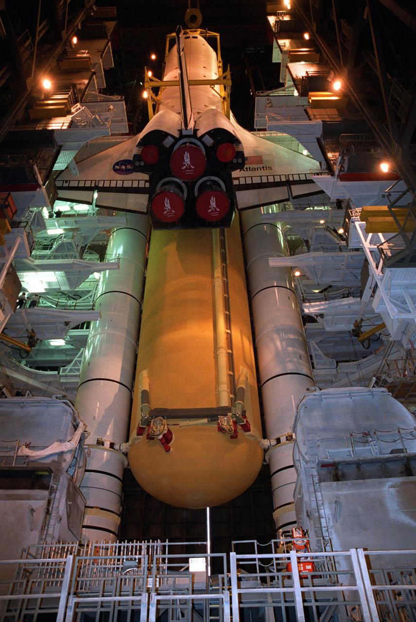 KENNEDY SPACE CENTER, FLA. -- In Vehicle Assembly Building high bay 1, the orbiter Atlantis is being lowered into position for mating to its external tank_solid rocket booster stack. Space Shuttle Atlantis is scheduled to launch on mission STS-104 in early July