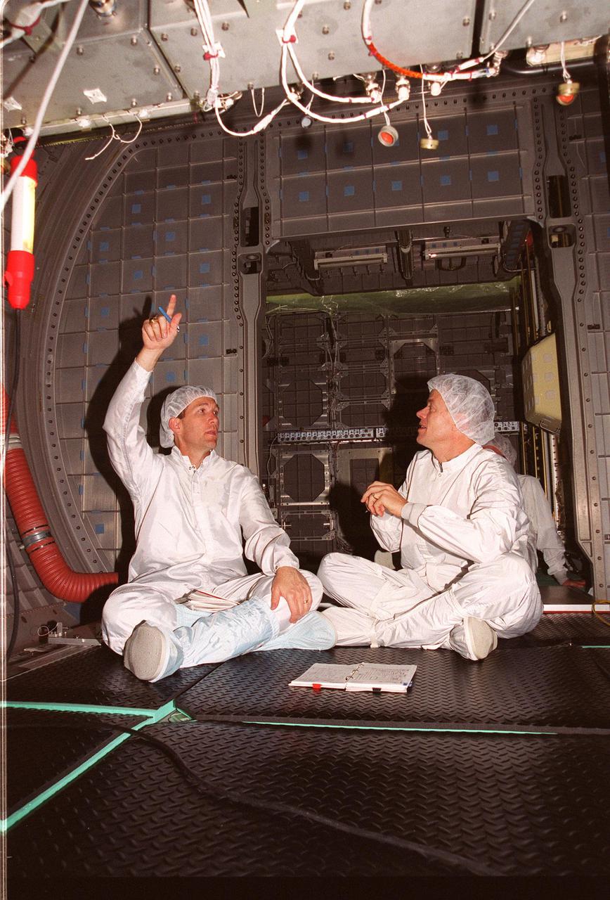 KENNEDY SPACE CENTER, Fla. -- - STS-107 Commander Rick D. Husband (left) and Pilot William C. McCool train in the SPACHEAB Double Module that will fly on their mission. Husband, McCool and other crew members Payload Commander Michael P. Anderson; Mission Specialists Laurel Blair Salton Clark and David M. Brown; and Payload Specialist Ilan Ramon, of Israel, are at SPACEHAB, Cape Canaveral, Fla., to take part in Crew Equipment Interface Test (CEIT) activities. The CEIT enables the crew to perform certain flight operations, operate experiments in a flight-like environment, evaluate stowage locations and obtain additional exposure to specific experiment operations. As a research mission, STS-107 will carry the SPACEHAB Double Module in its first research flight into space and a broad collection of experiments ranging from material science to life science. STS-107 is scheduled for launch May 23, 2002