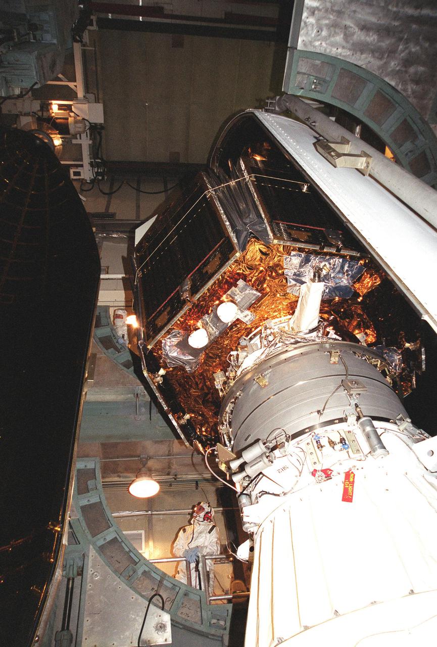 KENNEDY SPACE CENTER, Fla. -- At Launch Complex 17-B, Cape Canaveral Air Force Station, the Microwave Anisotropy Probe (MAP) spacecraft is encapsulated with the fairing. With one half already in place (right), the second half (left) moves into position. MAP is scheduled for launch on June 30 aboard a Boeing Delta II rocket. The launch will place MAP into a lunar-assisted trajectory to the Sun-Earth for a 27-month mission. The probe will measure small fluctuations in the temperature of the cosmic microwave background radiation to an accuracy of one millionth of a degree. These measurements should reveal the size, matter content, age, geometry and fate of the universe. They will also reveal the primordial structure that grew to form galaxies and will test ideas about the origins of these primordial structures. The MAP instrument will be continuously shaded from the Sun, Earth, and Moon by the spacecraft