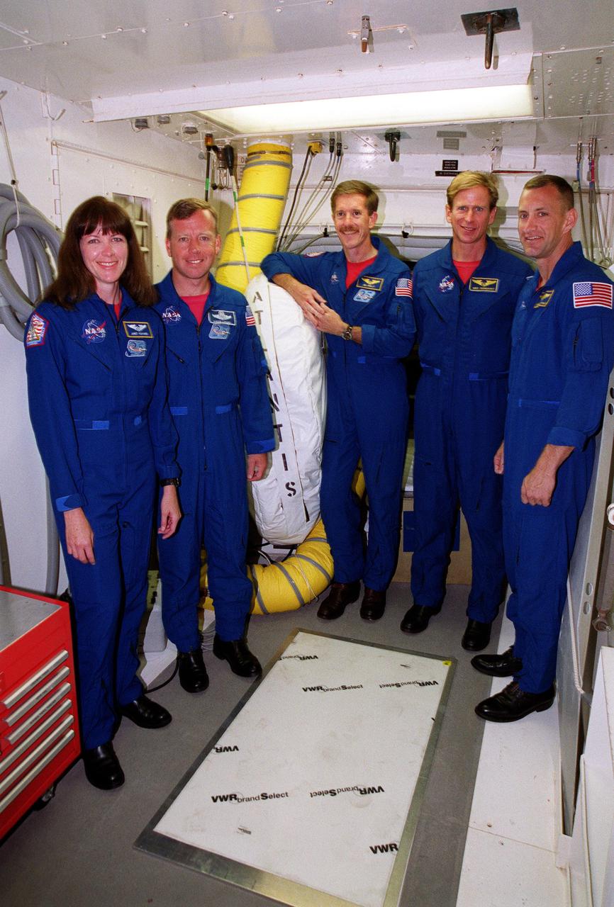 KENNEDY SPACE CENTER, Fla. -- The STS-104 crew pauses during Terminal Countdown Demonstration Test (TCDT) activities to pose for a group photo. Standing left to right are Mission Specialist Janet Lynn Kavandi, Commander Steven W. Lindsey, Mission Specialists James F. Reilly and Michael L. Gernhardt, and Pilot Charles O. Hobaugh. The TCDT includes emergency exit training from the orbiter, opportunities to inspect their mission payloads in the orbiter’s payload bay and simulated countdown exercises. The launch of Atlantis on mission STS-104 is scheduled July 12 from Launch Pad 39B. The mission is the 10th flight to the International Space Station and carries the Joint Airlock Module
