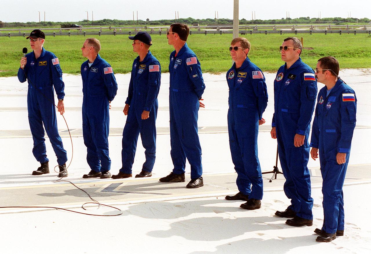 KENNEDY SPACE CENTER, Fla. -- At the slidewire landing site, Launch Pad 39A, STS-105 Mission Specialist Daniel Barry responds to a question during a media interview. With him are (left to right) Mission Specialist Patrick Forrester, Pilot Rick Sturckow and Commander Scott Horowitz; with the Expedition Three crew Commander Frank Culbertson and cosmonauts Vladimir Nikolaevich Dezhurov and Mikhail Tyurin, who are with the Russian Aviation and Space Agency. Both crews are at KSC to take part in Terminal Countdown Demonstration Test activities, which include emergency egress, a simulated launch countdown and familiarization with the payload. Mission STS-105 will be transporting the Expedition Three crew, several payloads and scientific experiments to the International Space Station aboard Discovery. The current Expedition Two crew members on the Station will return to Earth on Discovery. Launch of Discovery is scheduled no earlier than Aug. 9, 2001