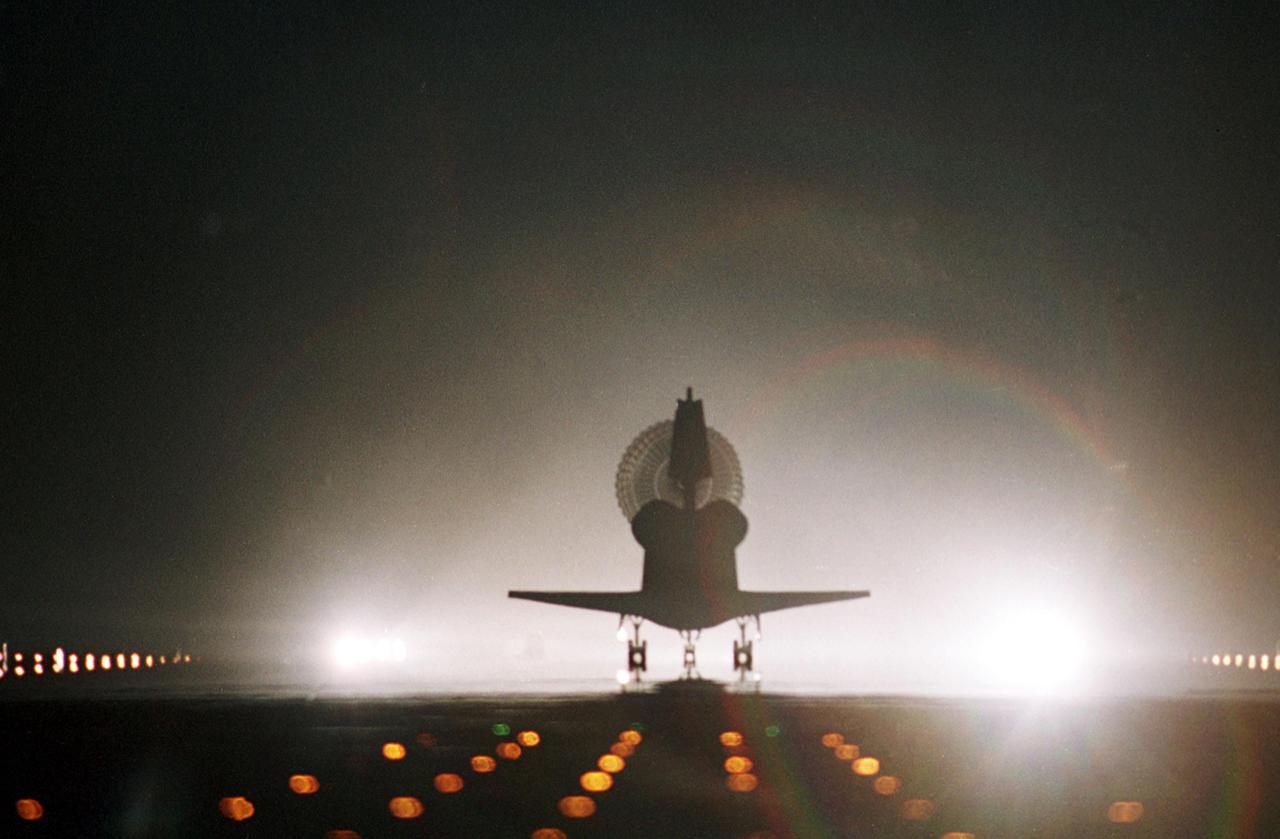 KENNEDY SPACE CENTER, Fla. -- Runway lights cast a rainbow from the colors in the drag chute behind Atlantis as it lands at the Shuttle Landing Facility. Main gear touchdown occurred at 11:38:55 p.m. EDT, completing complete a 12-day, 18-hour, 34-minute-long STS-104 mission. At the controls is Commander Steven W. Lindsey. Other crew members on board are Pilot Charles Hobaugh and Mission Specialists Michael Gernhardt, Janet Lynn Kavandi and James F. Reilly. This is the 18th nighttime landing for a Space Shuttle, the 13th at Kennedy Space Center. The mission delivered the Joint Airlock Module to the International Space Station, completing the second phase of the assembly of the Space Station