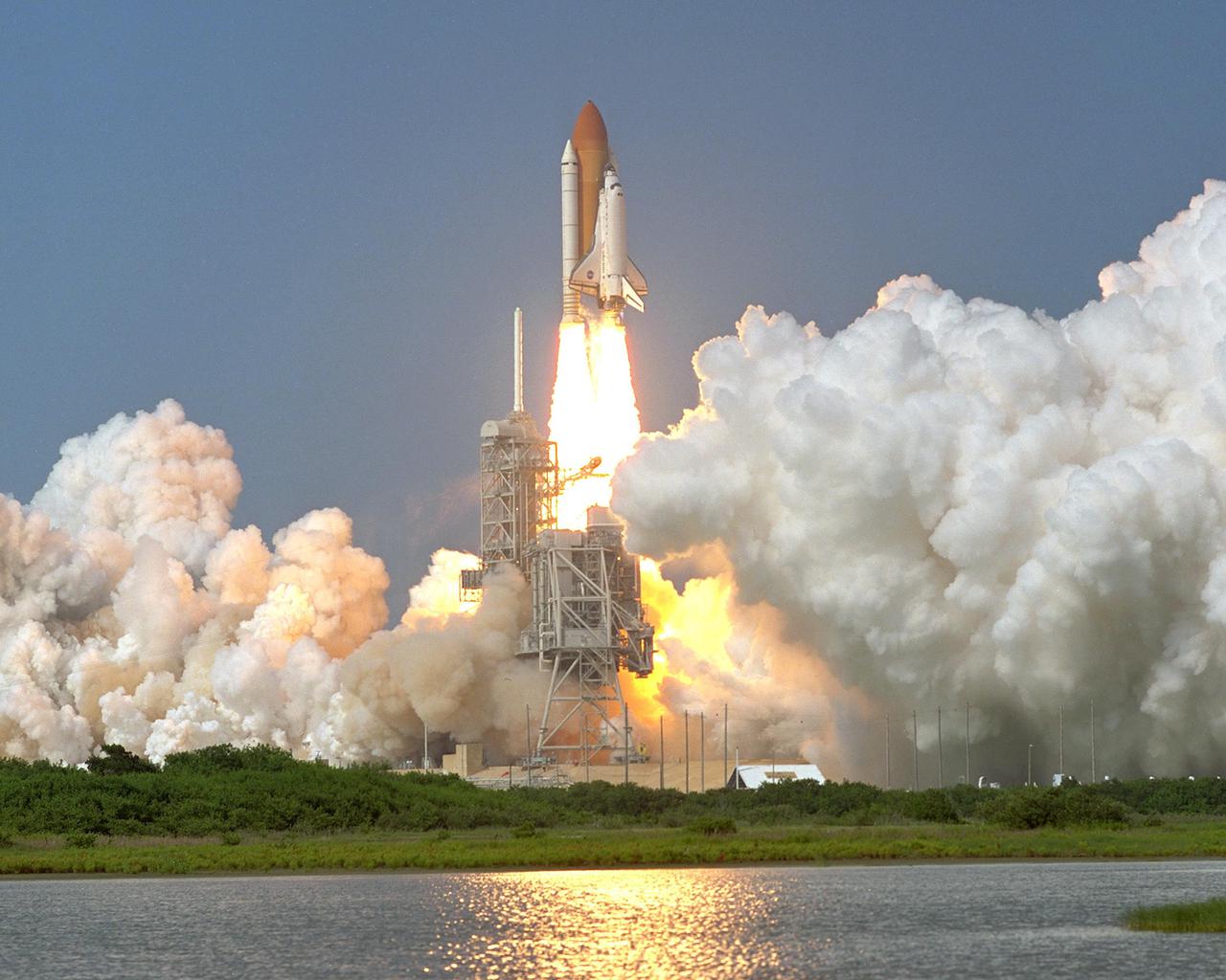 KENNEDY SPACE CENTER, Fla. -- Space Shuttle Discovery clears the lightning rod on Launch Pad 39A as it soars into the blue sky on mission STS-105 to the International Space Station. Liftoff occurred at 5:10:14 p.m. EDT on this second launch attempt. Launch countdown activities for the 12-day mission were called off Aug. 9 during the T-9 minute hold due to the high potential for lightning, a thick cloud cover and the potential for showers. Besides the Shuttle crew of four, Discovery carries the Expedition Three crew who will replace Expedition Two on the International Space Station. The mission includes the third flight of an Italian-built Multi-Purpose Logistics Module delivering additional scientific racks, equipment and supplies for the Space Station, and two spacewalks. Part of the payload is the Early Ammonia Servicer (EAS) tank, which will be attached to the Station during the spacewalks. The EAS contains spare ammonia for the Station’s cooling system. The three-member Expedition Two crew will be returning to Earth aboard Discovery after a five-month stay on the Station
