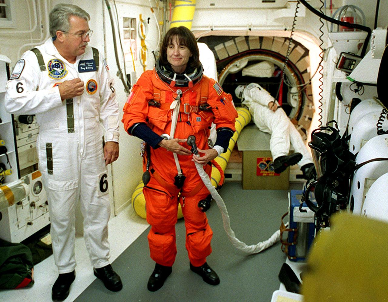 KENNEDY SPACE CENTER, Fla. -  STS-108 Mission Specialist Linda A. Godwin gets help with her launch and entry suit before entering Endeavour.   The main goals of the mission are to carry the Expedition 4 crew to the International Space Station as replacement for Expedition 3; carry the Multi-Purpose Logistics Module Raffaello filled with water, equipment and supplies; and  install thermal blankets over equipment at the base of the ISS solar wings. STS-108 is the final Shuttle mission of 2001 and the 107th Shuttle flight overall.  It is the 12th flight to the Space Station.  Launch is scheduled for 5:19 p.m. EST (22:19 GMT) Dec. 5, 2001, from Launch Pad 39B