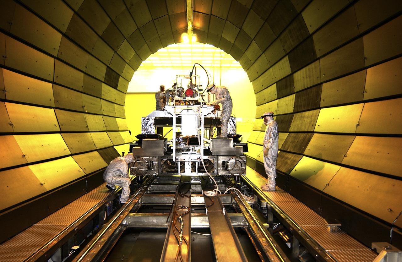 This photograph depicts the Solar X-Ray Imager (SXI) being installed in the X-Ray Calibration Facility (XRCF) vacuum chamber for testing at the Marshall Space Flight Center (MSFC). The XRCF vacuum chamber simulates a space environment with low temperature and pressure. The x-ray images from SXI on the Geostationary Operational Environmental Satellite-12 (GOES-12) will be used by the National Oceanic and Atmospheric Administration (NOAA) and U.S. Air Force to forecast the intensity and speed of solar disturbances that could destroy satellite electronics or disrupt long-distance radio communications. The SXI will observe solar flares, coronal mass ejections, coronal holes, and active regions in the x-ray region of the electromagnetic spectrum. These features are the dominant sources of disturbances in space weather. The imager instrument consists of a telescope assembly with a 6.3-inch (16-centimeter) diameter grazing incidence mirror and a detector system. The imager was developed, tested, and calibrated by MSFC, in conjunction with the NASA Goddard Space Flight Center and U.S. Air Force.