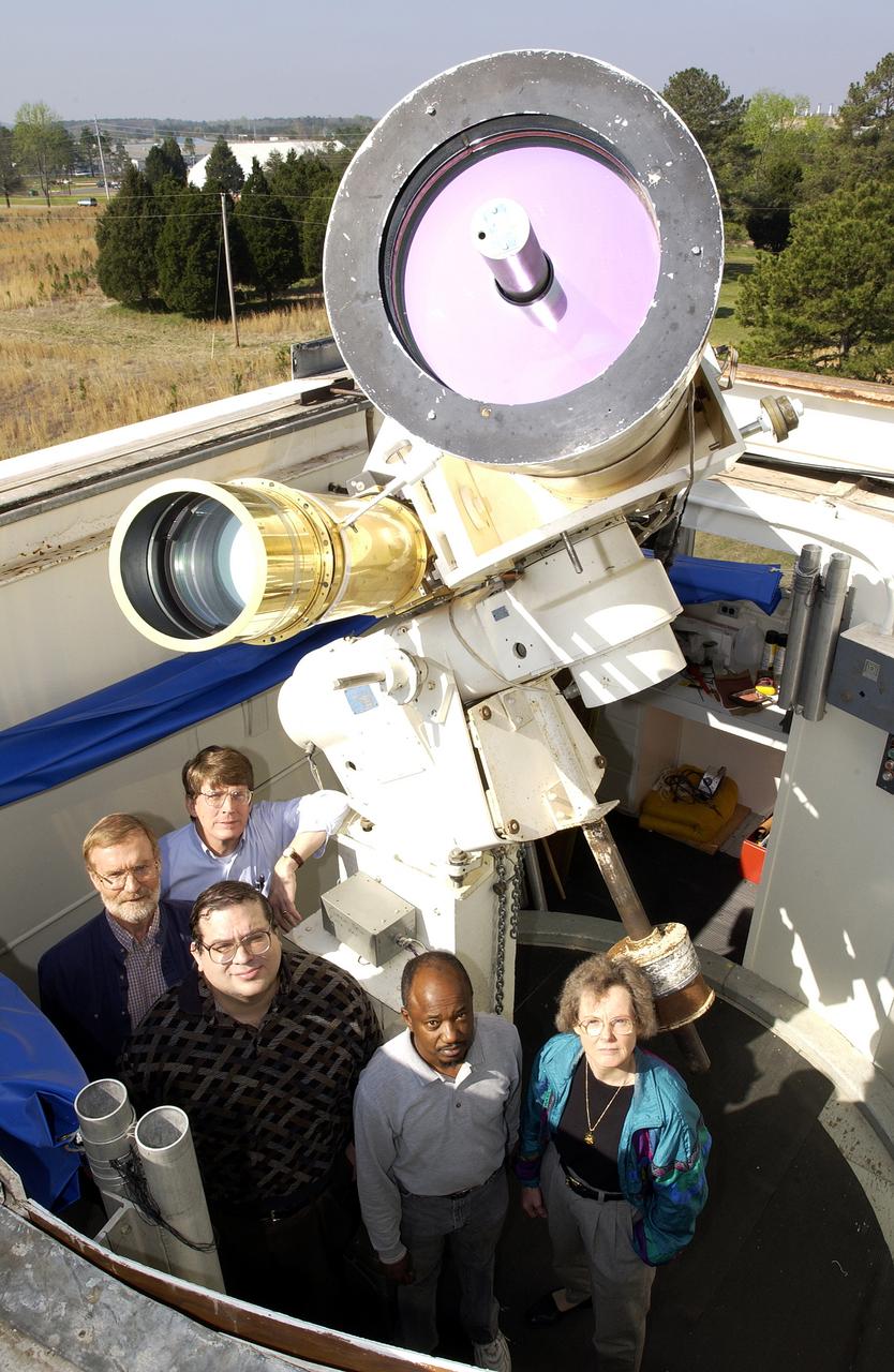 Using the Solar Vector Magnetograph, a solar observation facility at NASA's Marshall Space Flight Center (MSFC), scientists from the National Space Science and Technology Center (NSSTC) in Huntsville, Alabama, are monitoring the explosive potential of magnetic areas of the Sun. This effort could someday lead to better prediction of severe space weather, a phenomenon that occurs when blasts of particles and magnetic fields from the Sun impact the magnetosphere, the magnetic bubble around the Earth. When massive solar explosions, known as coronal mass ejections, blast through the Sun's outer atmosphere and plow toward Earth at speeds of thousands of miles per second, the resulting effects can be harmful to communication satellites and astronauts outside the Earth's magnetosphere. Like severe weather on Earth, severe space weather can be costly. On the ground, magnetic storms wrought by these solar particles can knock out electric power. Photographed are a group of contributing researchers in front of the Solar Vector Magnetograph at MSFC. The researchers are part of NSSTC's solar physics group, which develops instruments for measuring magnetic fields on the Sun. With these instruments, the group studies the origin, structure, and evolution of the solar magnetic fields and the impact they have on Earth's space environment.