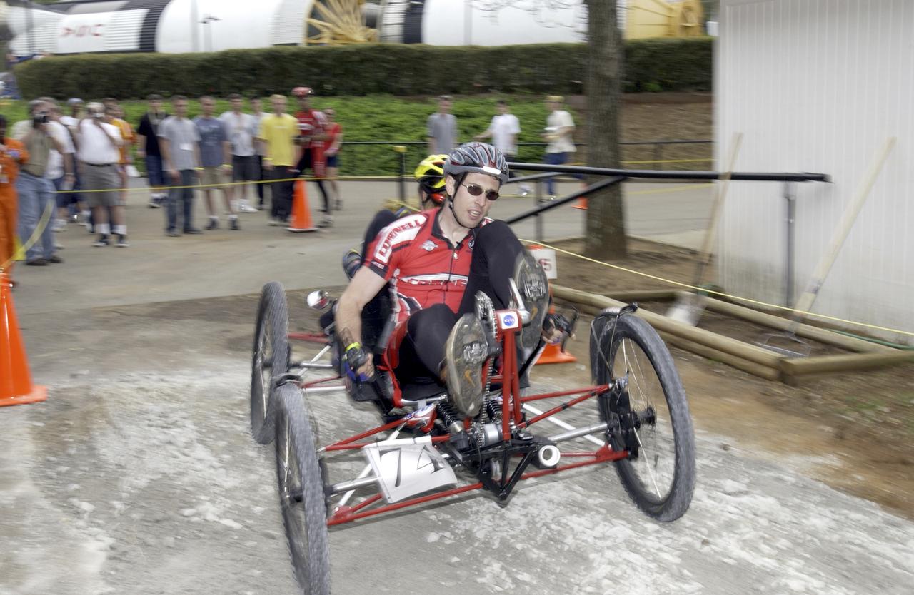 Students from across the United States and as far away as Puerto Rico and South America came to Huntsville, Alabama for the 9th annual Great Moonbuggy Race at the U.S. Space Rocket Center. Seventy-seven teams, representing high schools and colleges from 21 states, Puerto Rico, and Columbia, raced human powered vehicles over a lunar-like terrain. A team from Cornell University in Ithaca, New York, took the first place honor in the college division. In this photograph, the Cornell #1 team, the collegiate first place winner, maneuvers their vehicle through the course. Vehicles powered by two team members, one male and one female, raced one at a time over a half-mile obstacle course of simulated moonscape terrain. The competition is inspired by development, some 30 years ago, of the Lunar Roving Vehicle (LRV), a program managed by the Marshall Space Flight Center. The LRV team had to design a compact, lightweight, all-terrain vehicle that could be transported to the Moon in the small Apollo spacecraft. The Great Moonbuggy Race challenges students to design and build a humanpowered vehicle so they will learn how to deal with real-world engineering problems similar to those faced by the actual NASA LRV team.