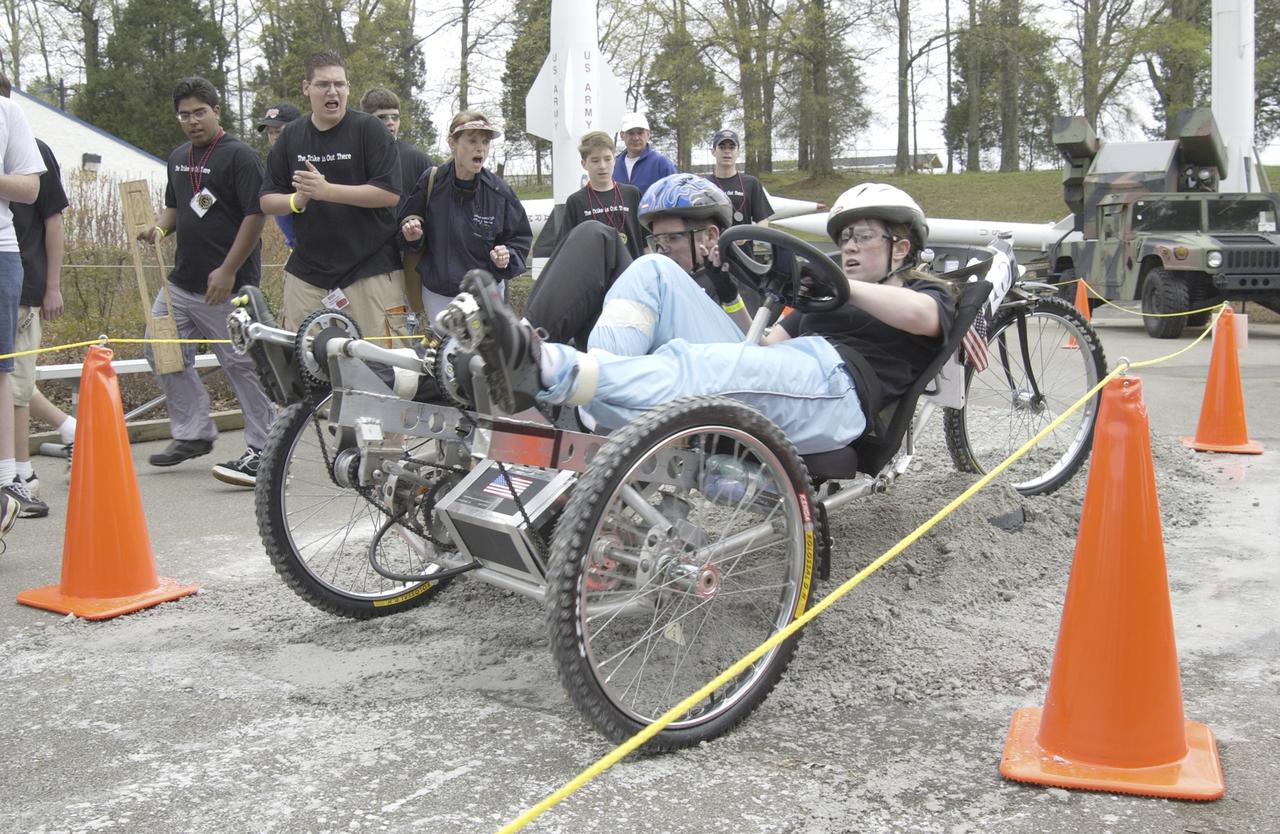 Students from across the United States and as far away as Puerto Rico and South America came to Huntsville, Alabama for the 9th annual Great Moonbuggy Race at the U.S. Space Rocket Center. Seventy-seven teams, representing high schools and colleges from 21 states, Puerto Rico, and Columbia, raced human powered vehicles over a lunar-like terrain. In this photograph, the New Orleans area schools team #2 from New Orleans, Louisiana maneuvers through an obstacle course. The team captured second place in the high school division competition. Vehicles powered by two team members, one male and one female, raced one at a time over a half-mile obstacle course of simulated moonscape terrain. The competition is inspired by the development, some 30 years ago, of the Lunar Roving Vehicle (LRV), a program managed by the Marshall Space Flight Center. The LRV team had to design a compact, lightweight, all-terrain vehicle that could be transported to the Moon in the small Apollo spacecraft. The Great Moonbuggy Race challenges students to design and build a human powered vehicle so they will learn how to deal with real-world engineering problems, similar to those faced by the actual NASA LRV team.