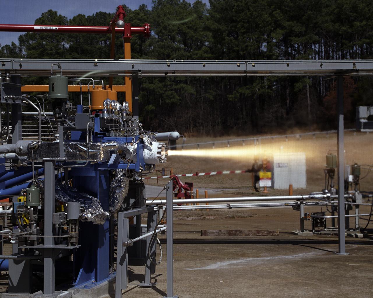 Engineers at the Marshall Space Flight Center (MSFC) have begun a series of engine tests on a new breed of space propulsion: a Reaction Control Engine developed for the Space Launch Initiative (SLI). The engine, developed by TRW Space and Electronics of Redondo Beach, California, is an auxiliary propulsion engine designed to maneuver vehicles in orbit. It is used for docking, reentry, attitude control, and fine-pointing while the vehicle is in orbit. The engine uses nontoxic chemicals as propellants, a feature that creates a safer environment for ground operators, lowers cost, and increases efficiency with less maintenance and quicker turnaround time between missions. Testing includes 30 hot-firings. This photograph shows the first engine test performed at MSFC that includes SLI technology. Another unique feature of the Reaction Control Engine is that it operates at dual thrust modes, combining two engine functions into one engine. The engine operates at both 25 and 1,000 pounds of force, reducing overall propulsion weight and allowing vehicles to easily maneuver in space. The low-level thrust of 25 pounds of force allows the vehicle to fine-point maneuver and dock while the high-level thrust of 1,000 pounds of force is used for reentry, orbit transfer, and coarse positioning. SLI is a NASA-wide research and development program, managed by the MSFC, designed to improve safety, reliability, and cost effectiveness of space travel for second generation reusable launch vehicles.