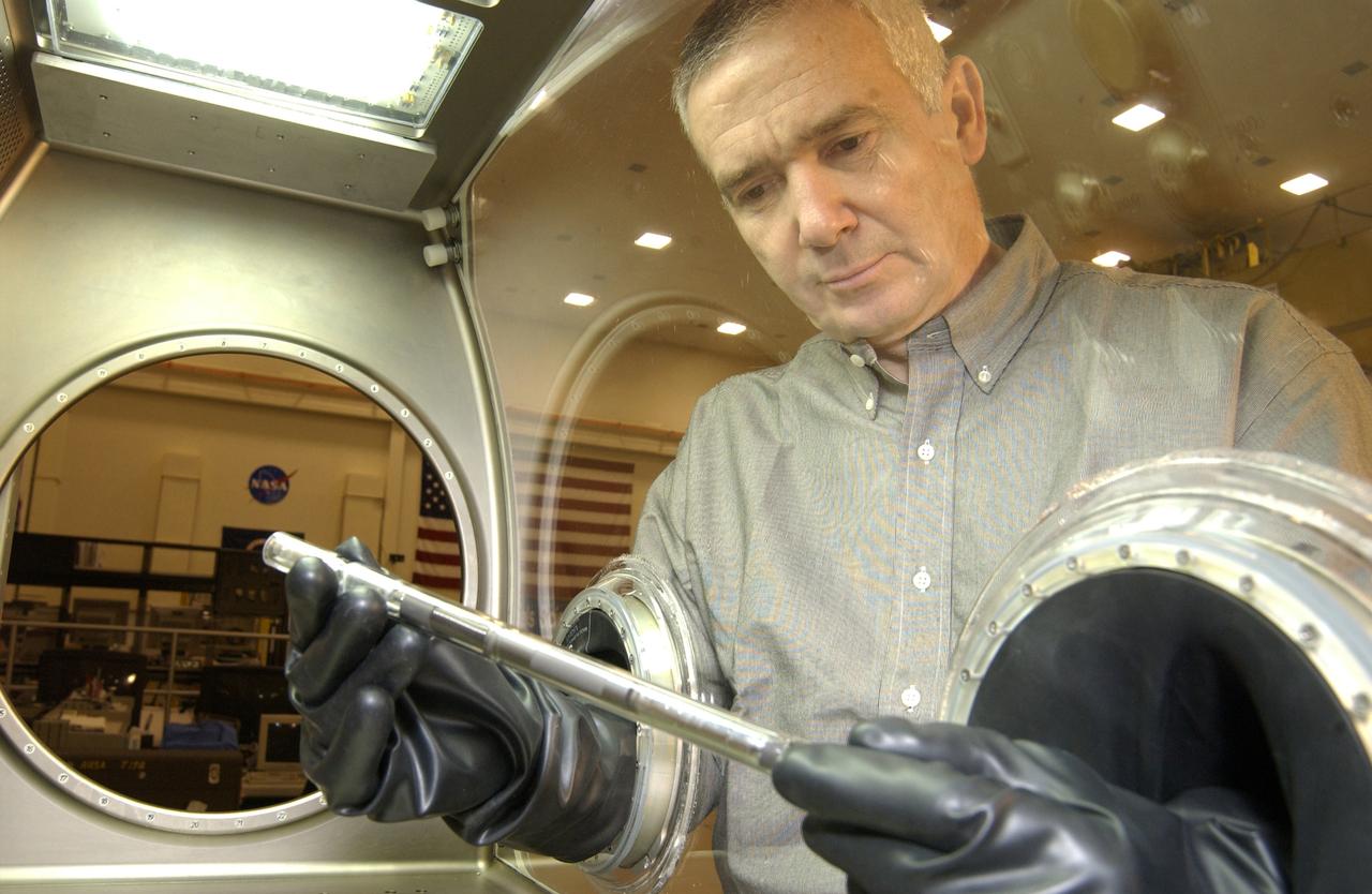 One of the first materials science experiments on the International Space Station -- the Solidification Using a Baffle in Sealed Ampoules (SUBSA) -- will be conducted during Expedition Five inside the Microgravity Science Glovebox. The glovebox is the first dedicated facility delivered to the Station for microgravity physical science research, and this experiment will be the first one operated inside the glovebox. The glovebox's sealed work environment makes it an ideal place for the furnace that will be used to melt semiconductor crystals. Astronauts can change out samples and manipulate the experiment by inserting their hands into a pair of gloves that reach inside the sealed box. Dr. Aleksandar Ostrogorsky, a materials scientist from the Rensselaer Polytechnic Institute, Troy, N.Y., and the principal investigator for the SUBSA experiment, uses the gloves to examine an ampoule like the ones used for his experiment inside the glovebox's work area. The Microgravity Science Glovebox and the SUBSA experiment are managed by NASA's Marshall Space Flight Center in Huntsville, Ala.