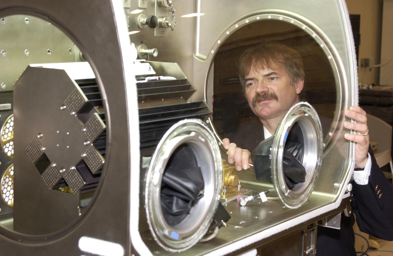 Dr. Richard Grugel, a materials scientist at NASA's Marshall Space Flight in Huntsville, Ala., examines the furnace used to conduct his Pore Formation and Mobility Investigation -- one of the first two materials science experiments to be conducted on the International Space Station. This experiment studies materials processes similar to those used to make components used in jet engines. Grugel's furnace was installed in the Microgravity Science Glovebox through the circular port on the side. In space, crewmembers are able to change out samples using the gloves on the front of the facility's work area.
