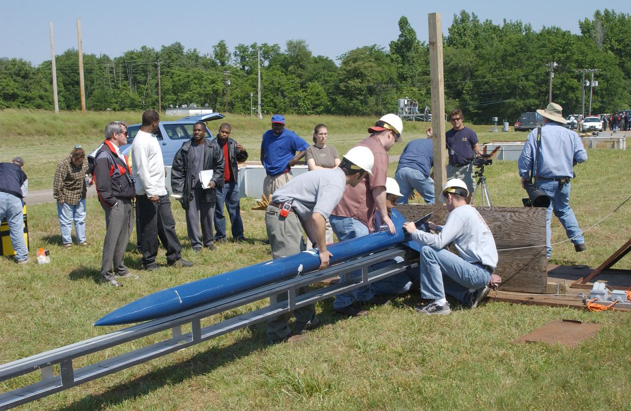 Filled with anticipation, students from two local universities, the University of Alabama in Huntsville (UAH), and Alabama Agricultural Mechanical University (AM), counted down to launch the rockets they designed and built at the Army test site on Redstone Arsenal in Huntsville, Alabama. The projected two-mile high launch culminated more than a year's work and demonstrated the student team's ability to meet the challenge set by the Marshall Space Flight Center's (MSFC) Student Launch Initiative (SLI) program to apply science and math to experience, judgment, and common sense, and proved to NASA officials that they have successfully built reusable launch vehicles (RLVs), another challenge set by NASA's SLI program. MSFC's SLI program is an educational effort that aims to motivate students to pursue careers in science, math, and engineering. It provides the students with hands-on, practical aerospace experience. In this picture, the University students prepare their rocket for launch. Students at UAH built the rocket and AM students developed its scientific payload, an experiment that measures the amount of hydrogen produced during electroplating with nickel in a brief period of micrgravity.