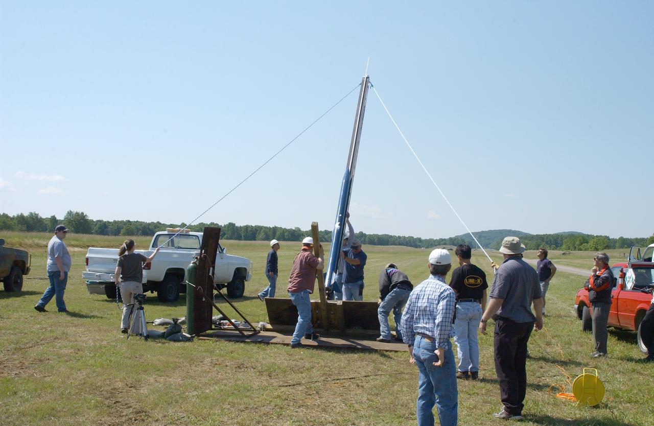 Filled with anticipation, students from two local universities, the University of Alabama in Huntsville (UAH), and Alabama Agricultural Mechanical University (AM), counted down to launch the rockets they designed and built at the Army test site on Redstone Arsenal in Huntsville, Alabama. The projected two-mile high launch culminated more than a year's work and demonstrated the student team's ability to meet the challenge set by the Marshall Space Flight Center's (MSFC) Student Launch Initiative (SLI) Program to apply science and math to experience, judgment, and common sense, and proved to NASA officials that they have successfully built reusable launch vehicles (RLVs), another challenge set by NASA's SLI program. MSFC's SLI program is an educational effort that aims to motivate students to pursue careers in science, math, and engineering. It provides the students with hands-on, practical aerospace experience. In this picture, the university students prepare their rocket for flight on the launch pad. Students at UAH built the rocket and AM students developed its scientific payload, an experiment that measures the amount of hydrogen produced during electroplating with nickel in a brief period of micrgravity.