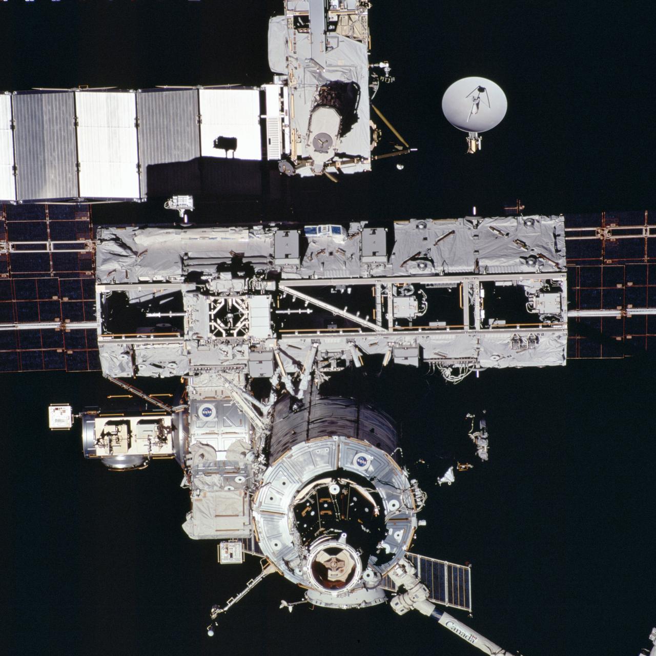 This close-up view of the International Space Station (ISS), newly equipped with its new 27,000-pound S0 (S-zero) truss, was photographed by an astronaut aboard the Space Shuttle Atlantis STS-110 during its ISS flyaround mission while pulling away from the ISS. The STS-110 mission prepared the Station for future spacewalks by installing and outfitting the 43-foot-long S0 truss and preparing the first railroad in space, the Mobile Transporter. The 27,000 pound S0 truss was the first of 9 segments that will make up the Station's external framework that will eventually stretch 356 feet (109 meters), or approximately the length of a football field. This central truss segment also includes a flatcar called the Mobile Transporter and rails that will become the first "space railroad," which will allow the Station's robotic arm to travel up and down the finished truss for future assembly and maintenance. The completed truss structure will hold solar arrays and radiators to provide power and cooling for additional international research laboratories from Japan and Europe that will be attached to the Station. STS-110 Extravehicular Activity (EVA) marked the first use of the Station's robotic arm to maneuver spacewalkers around the Station and was the first time all of a shuttle crew's spacewalks were based out of the Station's Quest Airlock. It was also the first Shuttle to use three Block II Main Engines. The Space Shuttle Orbiter Atlantis STS-110 mission, was launched April 8, 2002 and returned to Earth April 19, 2002.