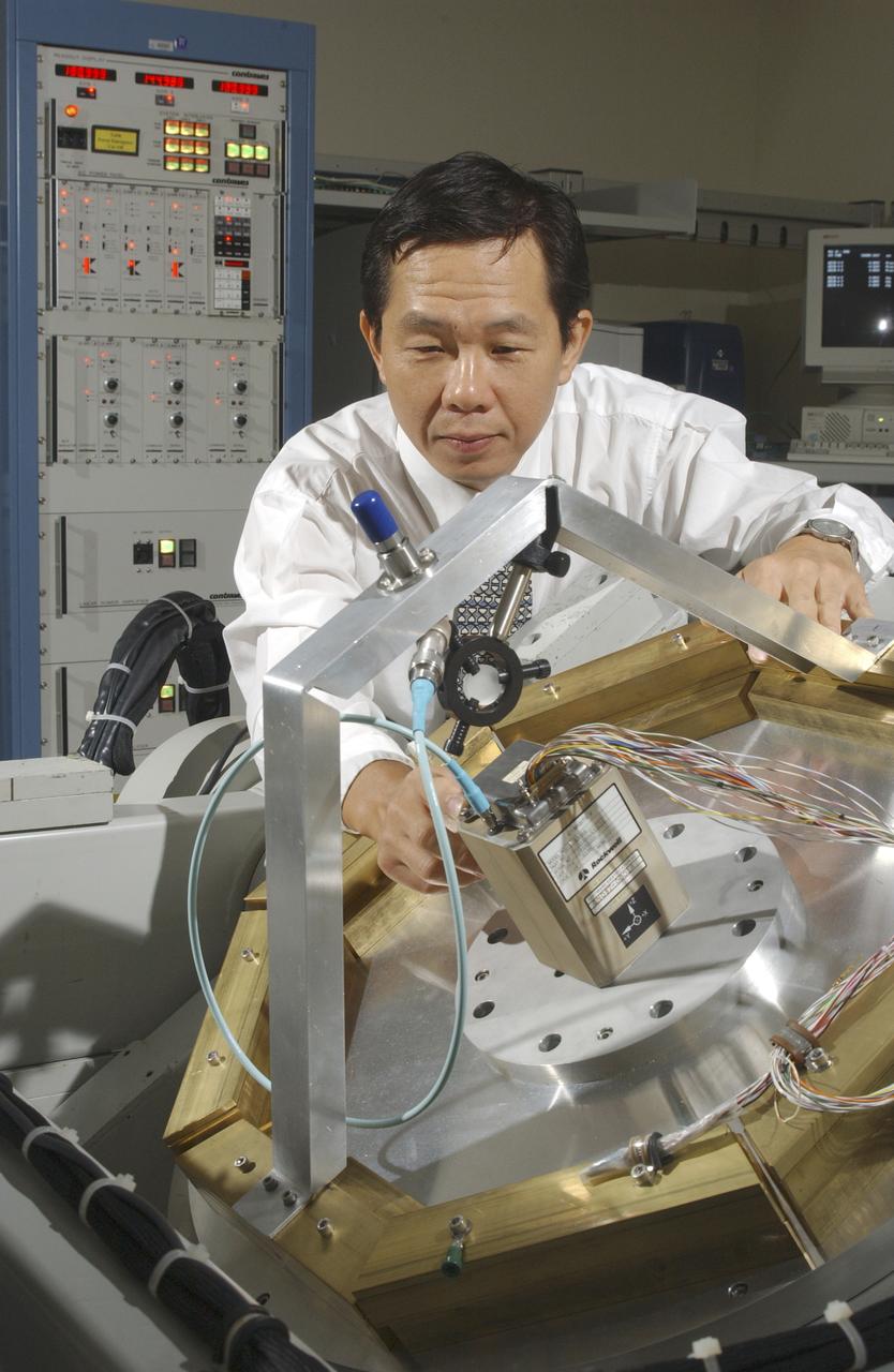 An array of components in a laboratory at NASA's Marshall Space Flight Center (MSFC) is being tested by the Flight Mechanics Office to develop an integrated navigation system for the second generation reusable launch vehicle. The laboratory is testing Global Positioning System (GPS) components, a satellite-based location and navigation system, and Inertial Navigation System (INS) components, sensors on a vehicle that determine angular velocity and linear acceleration at various points. The GPS and INS components work together to provide a space vehicle with guidance and navigation, like the push of the OnStar button in your car assists you with directions to a specific address. The integration will enable the vehicle operating system to track where the vehicle is in space and define its trajectory. The use of INS components for navigation is not new to space technology. The Space Shuttle currently uses them. However, the Space Launch Initiative is expanding the technology to integrate GPS and INS components to allow the vehicle to better define its position and more accurately determine vehicle acceleration and velocity. This advanced technology will lower operational costs and enhance the safety of reusable launch vehicles by providing a more comprehensive navigation system with greater capabilities. In this photograph, Dr. Jason Chuang of MSFC inspects an INS component in the laboratory.