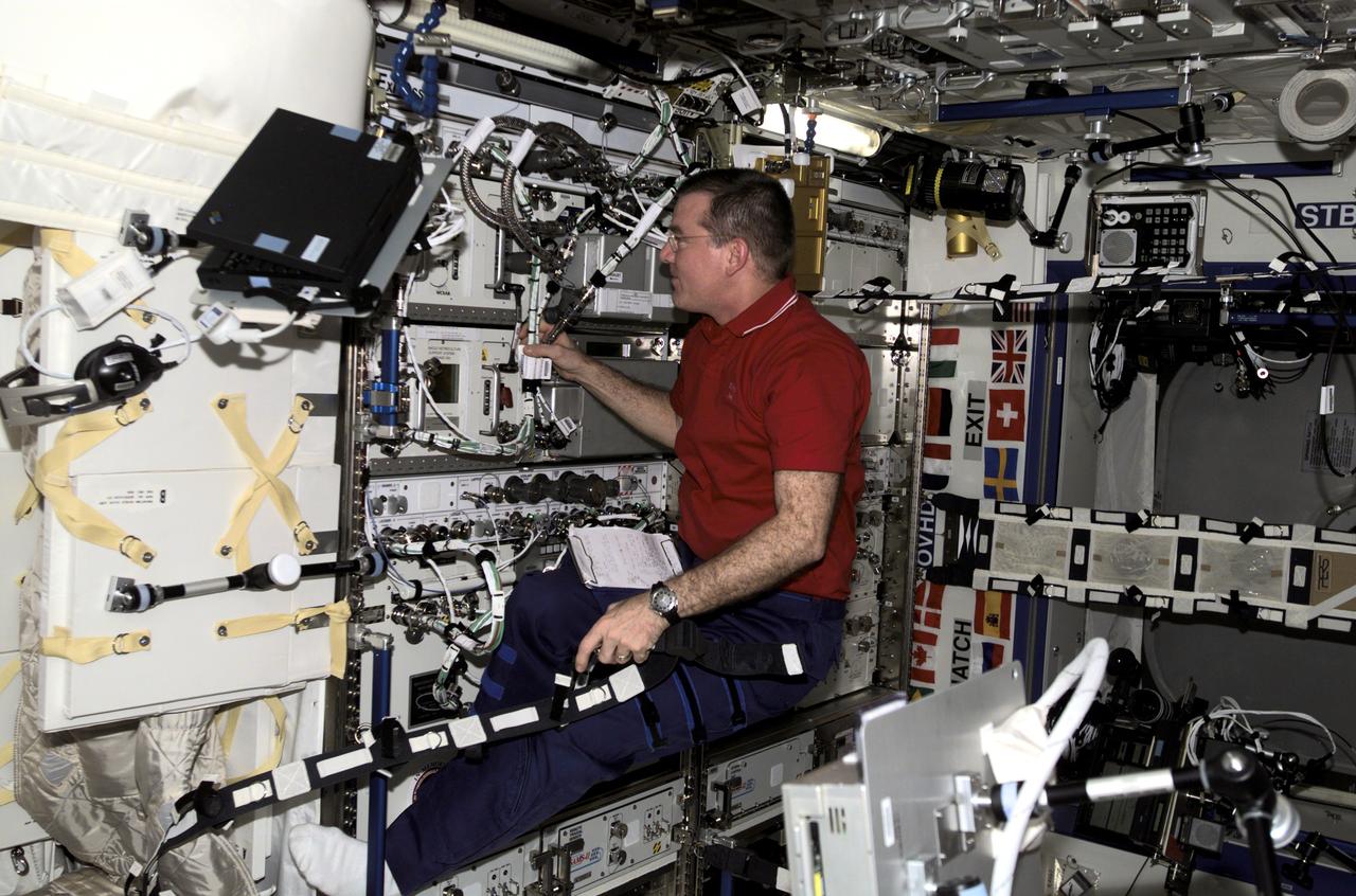 Astronaut James S. Voss, Expedition Two flight engineer, works with a series of cables on the EXPRESS Rack in the United State's Destiny laboratory on the International Space Station (ISS). The EXPRESS Rack is a standardized payload rack system that transports, stores, and supports experiments aboard the ISS. EXPRESS stands for EXpedite the PRocessing of Experiments to the Space Station, reflecting the fact that this system was developed specifically to maximize the Station's research capabilities. The EXPRESS Rack system supports science payloads in several disciplines, including biology, chemistry, physics, ecology, and medicine. With the EXPRESS Rack, getting experiments to space has never been easier or more affordable. With its standardized hardware interfaces and streamlined approach, the EXPRESS Rack enables quick, simple integration of multiple payloads aboard the ISS. The system is comprised of elements that remain on the ISS, as well as elements that travel back and forth between the ISS and Earth via the Space Shuttle.