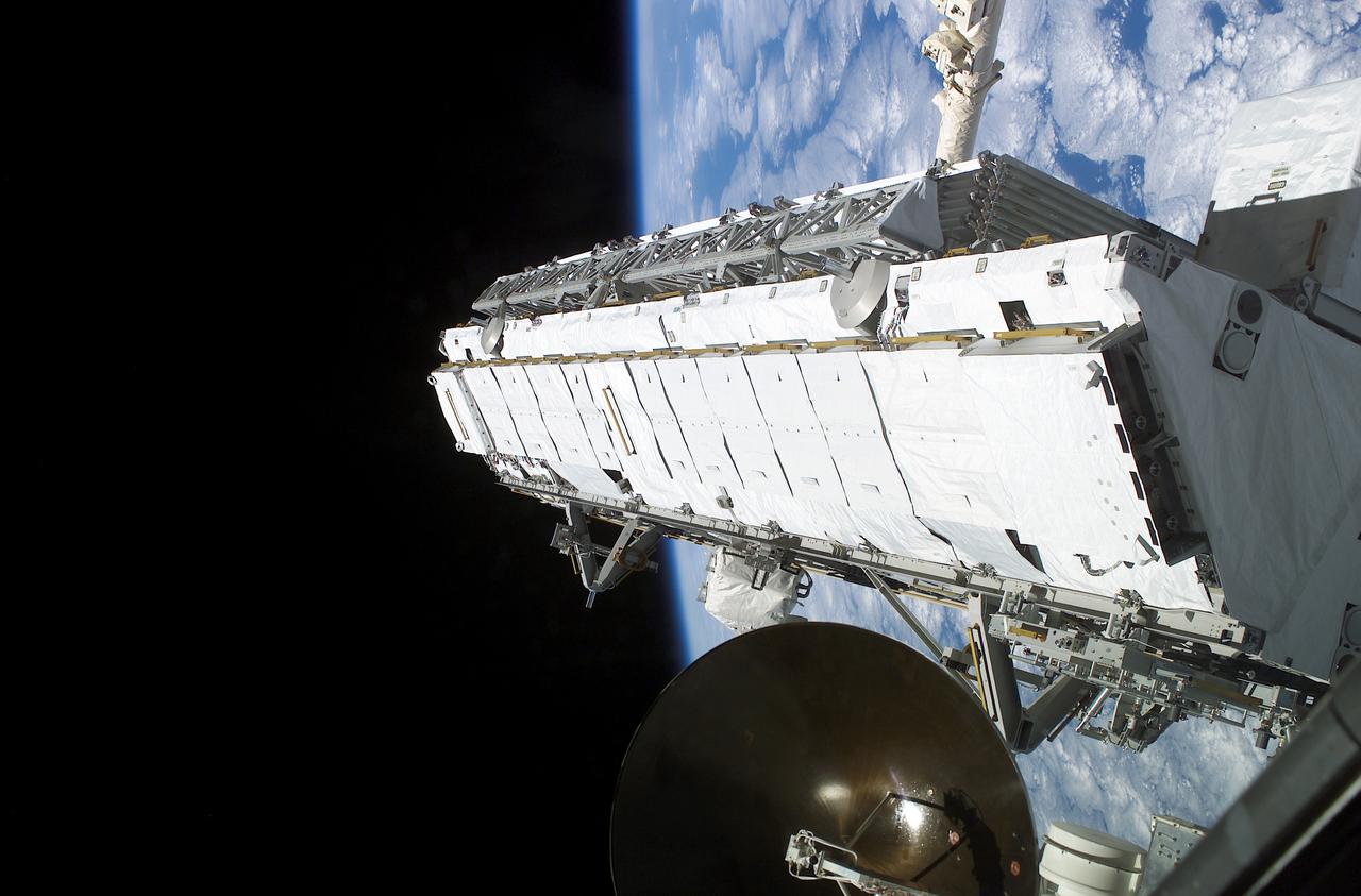 Being attached to the Canadarm2 on the International Space Station (ISS), the Remote Manipulator System arm built by the Canadian Space Agency, the Integrated Truss Assembly (S1) Truss is suspended over the Space Shuttle Orbiter Atlantis' cargo bay. Astronauts Sandra H. Magnus, STS-112 mission specialist, and Peggy A. Whitson, Expedition Five flight engineer, used the Canadarm2 from inside the Destiny laboratory on the ISS to lift the S1 truss out of the orbiter's cargo bay and move it into position prior to its installation on the ISS. The primary payloads of this mission, ISS Assembly Mission 9A, were the Integrated Truss Assembly S1 (S One), the starboard side thermal radiator truss, and the Crew Equipment Translation Aid (CETA) cart to the ISS. The S1 truss provides structural support for the orbiting research facility's radiator panels, which use ammonia to cool the Station's complex power system. The S1 truss was attached to the S0 (S Zero) truss, which was launched on April 8, 2002 aboard the STS-110, and flows 637 pounds of anhydrous ammonia through three heat-rejection radiators. The truss is 45-feet long, 15-feet wide, 10-feet tall, and weighs approximately 32,000 pounds. The CETA cart was attached to the Mobil Transporter and will be used by assembly crews on later missions. Manufactured by the Boeing Company in Huntington Beach, California, the truss primary structure was transferred to the Marshall Space Flight Center in February 1999 for hardware installations and manufacturing acceptance testing. The launch of the STS-112 mission occurred on October 7, 2002, and its 11-day mission ended on October 18, 2002.