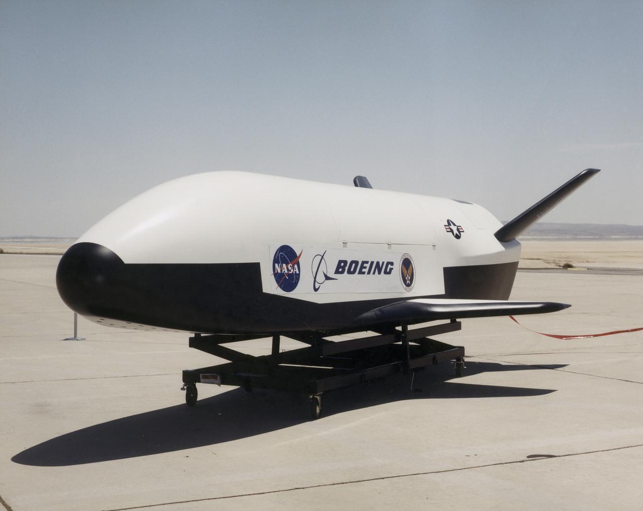 The photograph depicts the X-37 neutral buoyancy simulator mockup at Dryden Flight Research Center. The X-37 experimental launch vehicle is roughly 27.5 feet (8.3 meters) long and 15 feet (4.5 meters) in wingspan. Its experiment bay is 7 feet (2.1 meters) long and 4 feet (1.2 meters) in diameter. Designed to operate in both the orbital and reentry phases of flight, the X-37 will increase both safety and reliabiltiy, while reducing launch costs from $10,000 per pound to $1000 per pound. Managed by Marshall Space Flight Center and built by the boeing Company, the X-37 is scheduled to fly two orbital missions in 2002/2003 to test the reusable launch vehicle technologies.