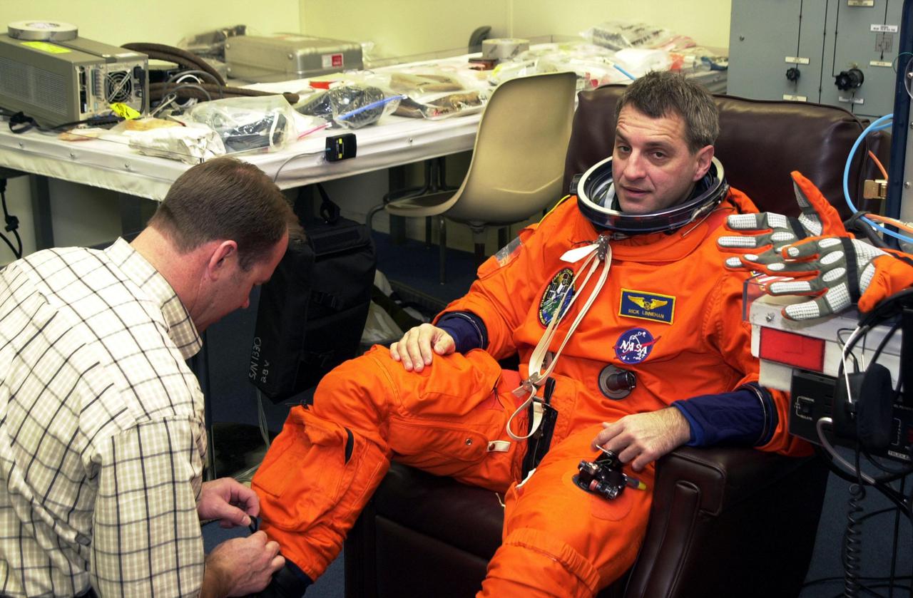 KENNEDY SPACE CENTER, FLA. --  STS-109 Mission Specialist Richard Linnehan gets a suit check during Terminal Countdown Demonstration Test activities.   He and other crew members - Commander Scott Altman, Pilot Duane Carey, Payload Commander John Grunsfeld and Mission Specialists Nancy Currie, James Newman and Michael Massimino - are at Kennedy for the TCDT that also includes emergency egress training and a simulated countdown.  Columbia is scheduled to be launched Feb. 28 on mission STS-109, a Hubble Servicing Mission. The goal of the mission is to replace Solar Array 2 with Solar Array 3, replace the Power Control Unit, remove the Faint Object Camera and install the ACS, install the Near Infrared Camera and Multi-Object Spectrometer (NICMOS) Cooling System, and install New Outer Blanket Layer insulation.  The launch will be the first for Columbia after returning from California where it underwent extensive maintenance, inspections and enhancements. More than 100 upgrades make Columbia safer and more reliable than ever before