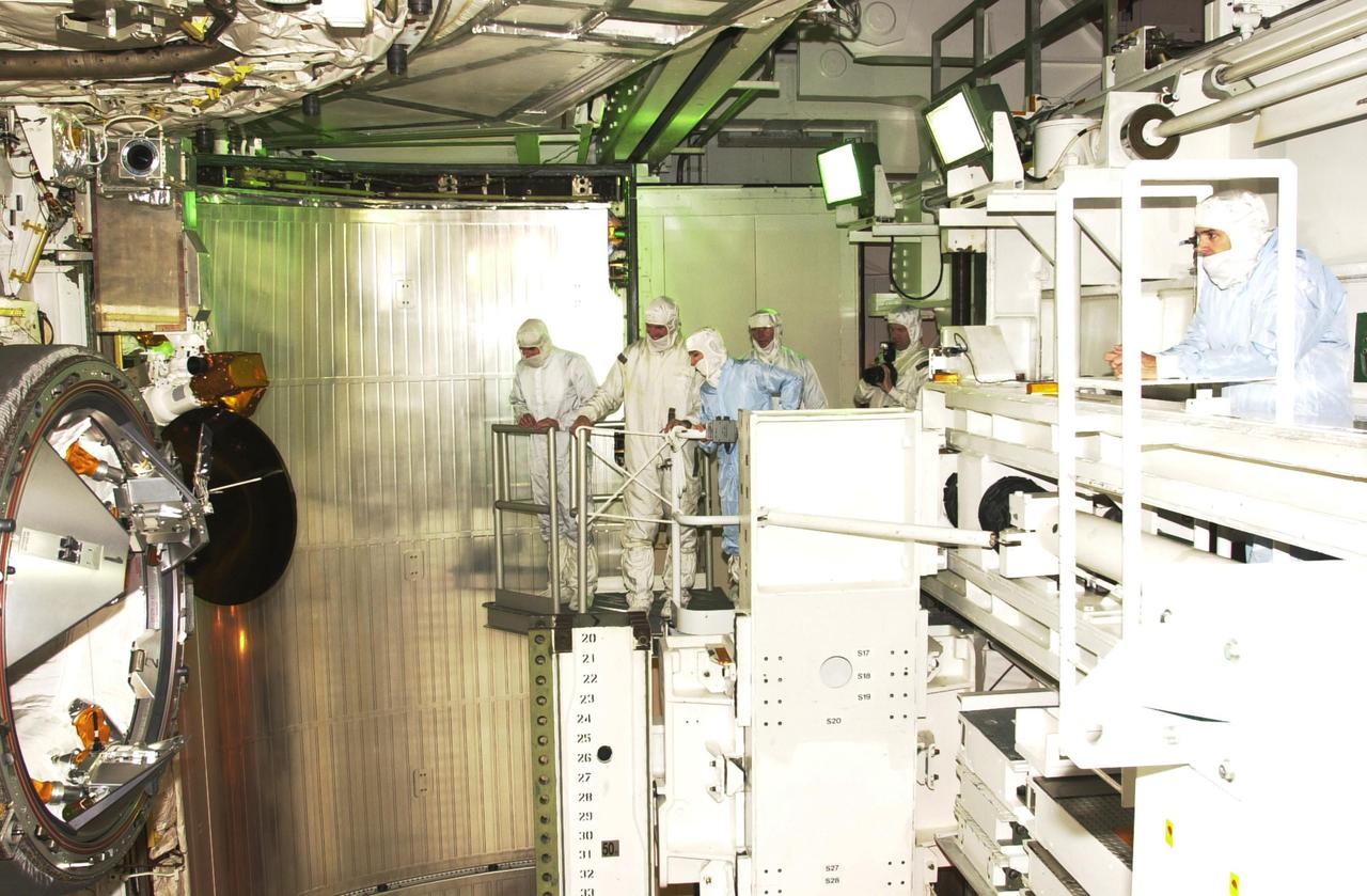 KENNEDY SPACE CENTER, FLA. - STS-110 crew members (center and right) are in the Payload Changeout Room at the pad performing a final inspection of the S-Zero Truss_Mobile Transporter payload and checking for any sharp edges they may encounter during the mission's four scheduled spacewalks. The payload doors were closed after the astronauts departed for their crew quarters