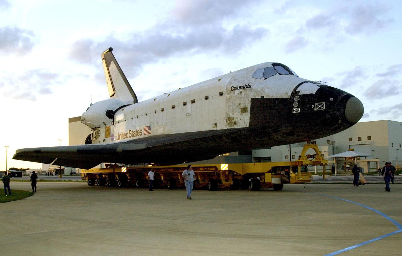 KENNEDY SPACE CENTER, FLA. --  The orbiter Columbia, atop a transporter, rolls away from the Orbiter Processing Facility on its way to the Vehicle Assembly Building.  There it will be mated with the external tank-solid rocket booster stack.   Columbia is scheduled to be launched Feb. 28 on mission STS-109, a Hubble Servicing Mission. The goal of the mission is to service the HST, replacing Solar Array 2 with Solar Array 3, replacing the Power Control Unit, removing the Faint Object Camera and installing the ACS, installing the Near Infrared Camera and Multi-Object Spectrometer (NICMOS) Cooling System, and installing New Outer Blanket Layer insulation
