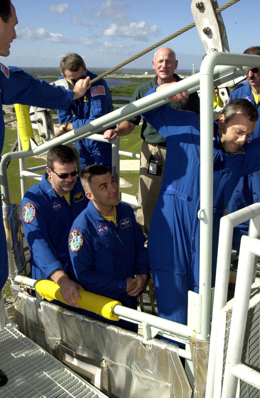 KENNEDY SPACE CENTER, FLA. --  On Launch Pad 39A, the STS-109 crew takes part in slidewire basket_ emergency egress training on the 195-foot level.  In the basket are (left to right) Commander Scott Altman, Pilot Duane Carey and Mission Specialist Michael Massimino.  Outside the basket, at left, is Mission Specialist James Newman.  On the other side are (left to right) Mission Specialist Richard Linnehan, the trainer, and Mission Specialist John Grunsfeld.  Not seen is Mission Specialist Nancy Currie.  The training is part of Terminal Countdown Demonstration Test activities that include a simulated countdown at the pad.  Columbia is scheduled to be launched Feb. 28 on mission STS-109, a Hubble Servicing Mission. The goal of the mission is to replace Solar Array 2 with Solar Array 3, replace the Power Control Unit, remove the Faint Object Camera and install the ACS, install the Near Infrared Camera and Multi-Object Spectrometer (NICMOS) Cooling System, and install New Outer Blanket Layer insulation. .  The launch will be the first for Columbia after returning from California where it underwent extensive maintenance, inspections and enhancements. More than 100 upgrades make Columbia safer and more reliable than ever before