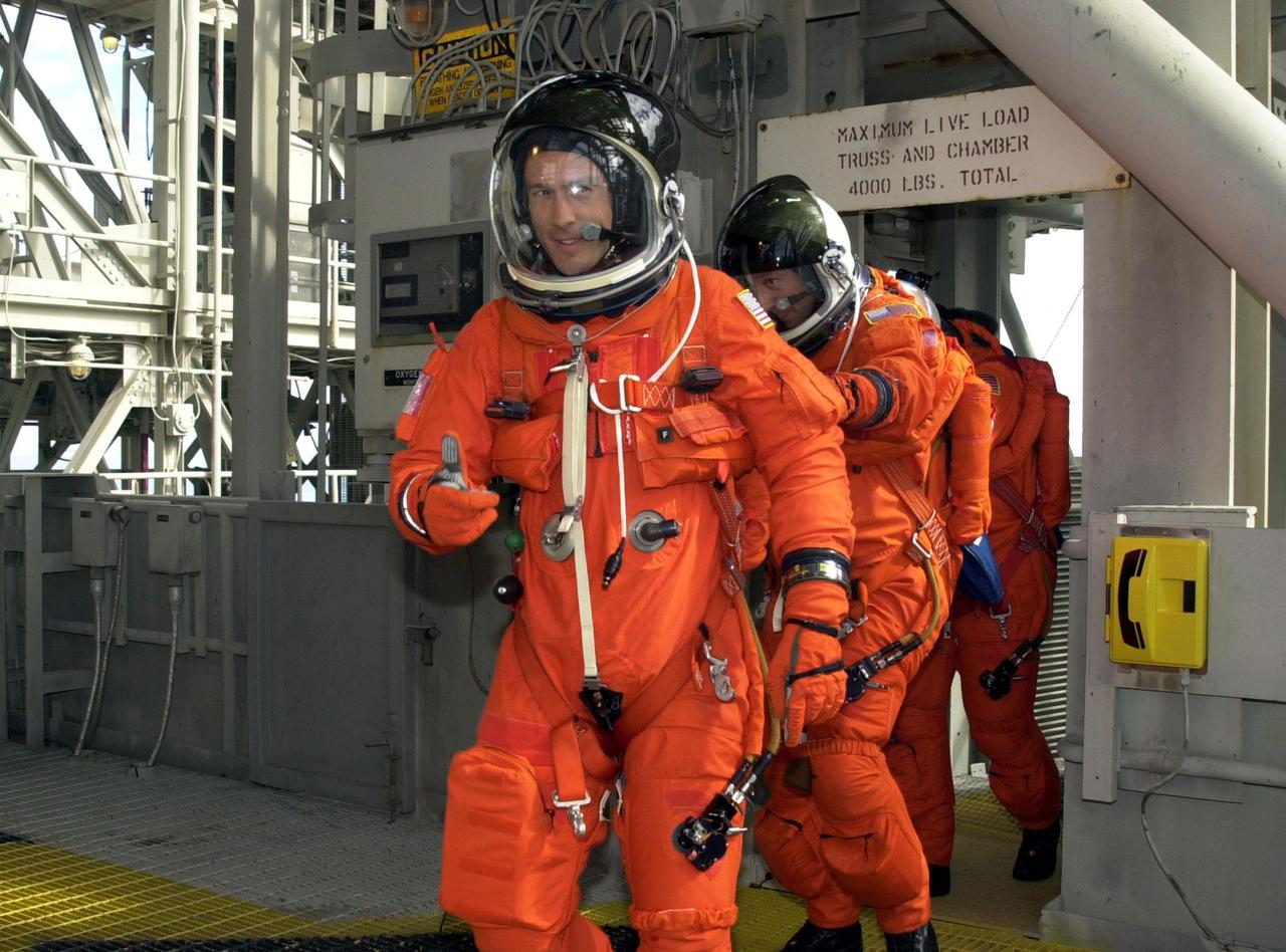 KENNEDY SPACE CENTER, FLA. -- As part of Terminal Countdown Demonstration Test activities, the STS-109 crew practices emergency exit from the Shuttle. Leading the way to the slidewire basket is Mission Specialist James Newman, followed by Michael Massimino and Richard Linnehan. The TCDT also includes a simulated launch countdown. STS-109 is a Hubble Space Telescope Servicing Mission, with goals to replace Solar Array 2 with Solar Array 3, replace the Power Control Unit, remove the Faint Object Camera and install the Advanced Camera for Surveys (ACS), install the Near Infrared Camera and Multi-Object Spectrometer (NICMOS) Cooling System, and install New Outer Blanket Layer insulation. The 11-day mission will require five spacewalks to perform the tasks. Launch of STS-109 aboard Space Shuttle Columbia is scheduled for Feb. 28, 2002