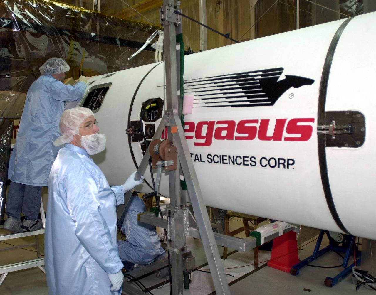 VANDENBERG AFB, CALIF. -- Technicians work on the Pegasus XL rocket, the vehicle that will launch the High Energy Solar Spectroscopic Imager (HESSI). The primary mission of HESSI is to explore the basic physics of particle acceleration and energy release in solar flares. The launch of PegasusXL_HESSI is scheduled for Feb. 5, 2002, from beneath an Orbital Sciences Corp. L-1011 aircraft over the Atlantic Ocean