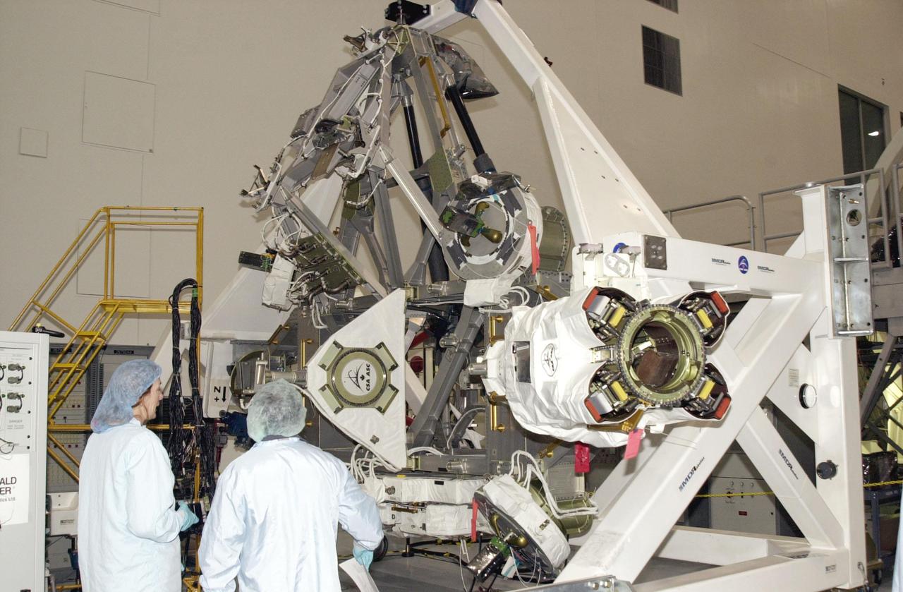 KENNEDY SPACE CENTER, FLA. -- Workers in the Space Station Processing Facility look over the Mobile Base System (MBS), part of the payload on mission STS-111 to the International Space Station. The MBS will be installed on the Mobile Transporter to complete the Canadian Mobile Servicing System, or MSS. The mechanical arm will then have the capability to 'inchworm' from the U.S. Lab Destiny to the MSS and travel along the truss to work sites. STS-111 is the second utilization flight (UF-2) to the Space Station and will also carry the Expedition 5 crew to replace Expedition 4. Launch is scheduled for May 2, 2002