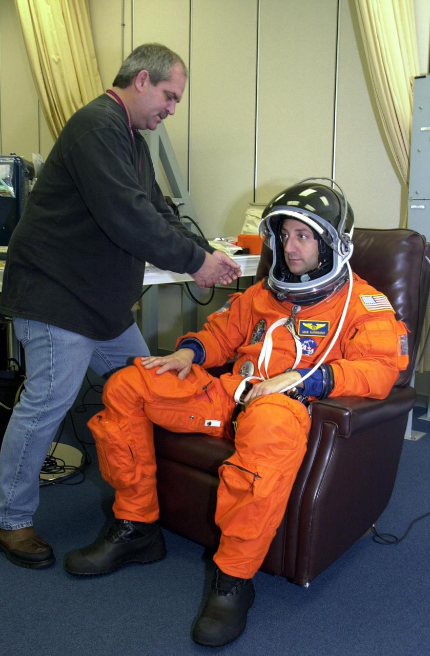 KENNEDY SPACE CENTER, Fla. -  STS-109 Mission Specialist Michael J. Massimino gets a final fitting on his launch and entry suit two days before launch.  On mission STS-109, the seven-member crew will capture the Hubble Space Telescope using the Shuttle's robotic arm and secure it on a workstand in Columbia's payload bay.  Four mission specialists will perform five scheduled spacewalks to complete system upgrades to the telescope. More durable solar arrays, a large gyroscopic assembly to help point the telescope properly, a new telescope power control unit, and a cooling system to restore the use of a key infrared camera and spectrometer unit, which has been dormant since 1999, will all be installed.  In addition, the telescope’s view of the Universe will be improved with the addition of the Advanced Camera for Surveys (ACS), which replaces the Faint Object Camera, the last of Hubble's original instruments.  The STS-109 crew also includes Commander Scott D. Altman, Pilot Duane G. Carey, and Mission Specialists John M. Grunsfeld, James H. Newman, Nancy J. Currie and Richard M. Linnehan.  Launch is scheduled for Feb. 28, 2002, at 6:48 a.m. EST (11:48 GMT)
