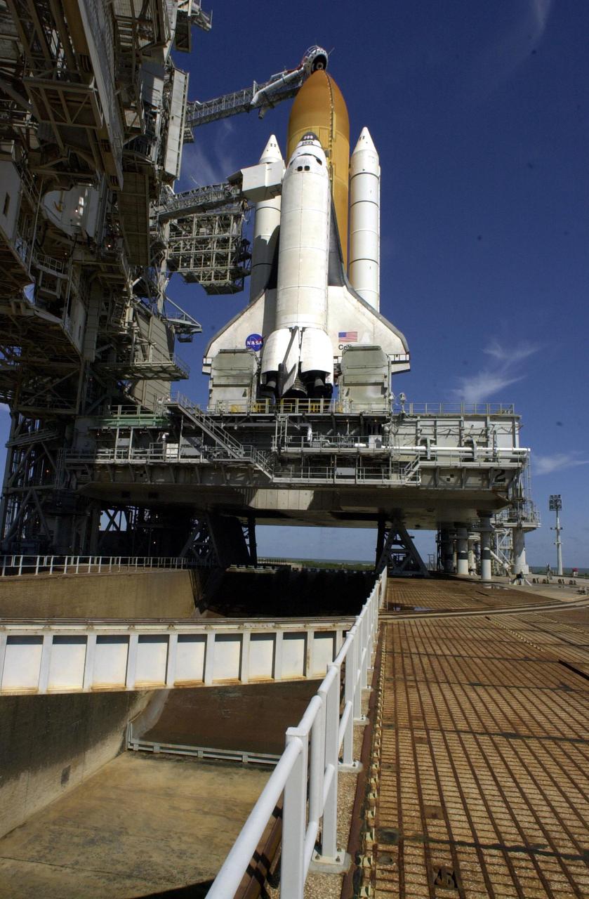 KENNEDY SPACE CENTER, Fla. - The Rotating Service Structure has rolled back to launch position for the second time in two days after a scrub of mission STS-109 the day before.  NASA managers had determined the unseasonably cold weather predicted at launch time was at the margin of acceptable limits.  This view shows Space Shuttle Columbia atop the Mobile Launcher Platform (MLP) on Launch Pad 39A.  Twin solid rocket boosters flank the orange-colored external tank.  Above the tank is the 'beanie cap,' the gaseous oxygen vent hood.   Below the MLP is the flame trench that helps deflect the intense heat and flames away from the vehicle as it lifts off.  Columbia is rescheduled for launch on mission STS-109 March 1 at 6:22 a.m. EST (11:22 GMT).  The 11-day mission will provide maintenance and upgrade to the Hubble Space Telescope, replacing Solar Array 2 with Solar Array 3, replacing the Power Control Unit, installing the ACS (after removing the Faint Object Camera ), the Near Infrared Camera, the Multi-Object Spectrometer (NICMOS) Cooling System, and the New Outer Blanket Layer insulation.
