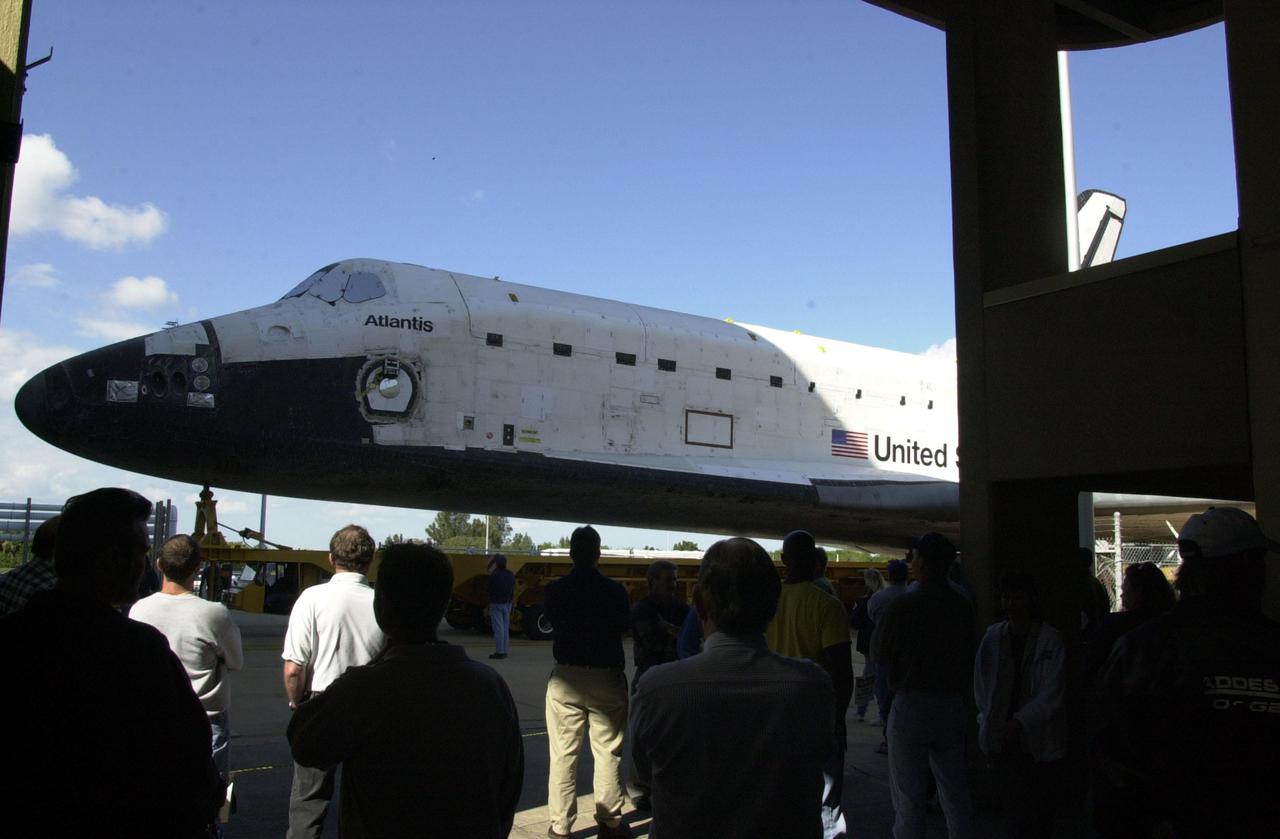 KENNEDY SPACE CENTER, Fla. - Employees watch as Orbiter Atlantis rolls out of the Orbiter Processing Facility on its way to the Vehicle Assembly Building for space vehicle mate.  As part of final preparations before transfer to the launch pad, Atlantis will be lifted vertically into its VAB high bay and mated to the twin solid rocket boosters and external tank.  The STS-110 mission resumes International Space Station assembly operations with the delivery of the S0 truss, which will support solar panels providing additional power to the Station.  The payload will also include the first part of a Mobile Transporter that will provide a moveable base for the Station’s Canadian robotic arm.  STS-110 is scheduled for launch April 4
