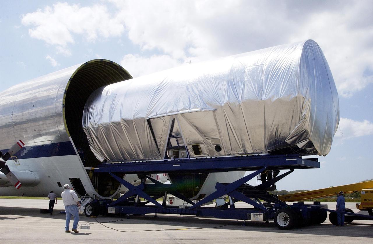 KENNEDY SPACE CENTER, FLA. -- The S5 truss segment for the International Space Station is offloaded from the Super Guppy transport aircraft at the KSC Shuttle Landing Facility. The S5 truss will be transferred to the Space Station Processing Facility where it will be fit checked for a Photo-Voltaic Radiator Grapple Fixture. It will also undergo a fit check to a truss simulator to make sure S5 will fit together with the S4 and S6 truss segments. S5 is scheduled for launch in October 2003 on mission STS-118. It will be the 10th truss assembled as part of a total 11 trusses.