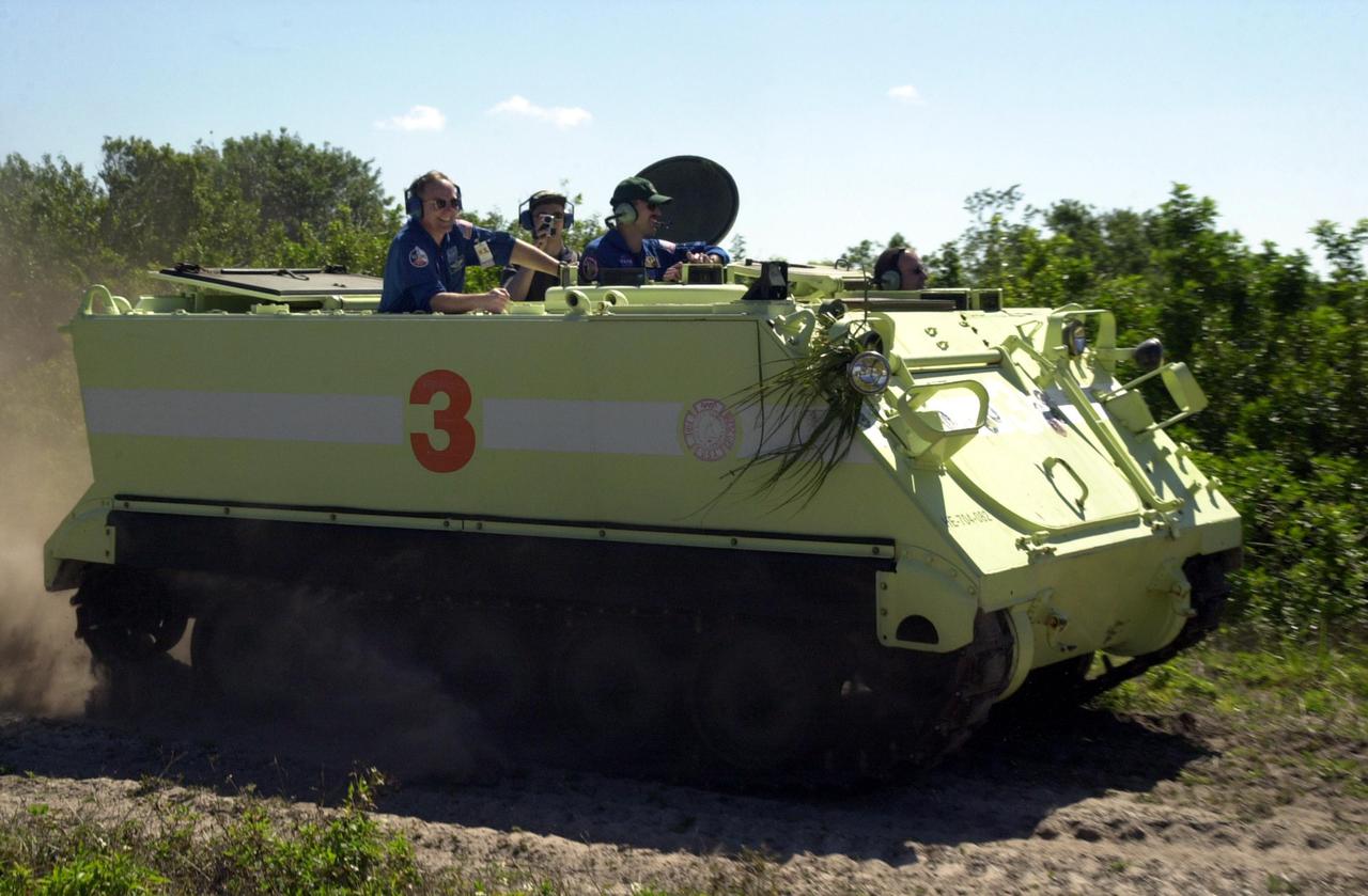 KENNEDY SPACE CENTER, FLA. --  With STS-110 Mission Specialists Jerry Ross (far left) and Steven Smith (third from left) on board, Commander Michael Bloomfield scatters dust as he practices driving the M-113 armored personnel carrier. The driving is part of Terminal Countdown Demonstration Test activities, which include emergency egress training and a simulated launch countdown. The TCDT is held at KSC prior to each Space Shuttle flight.  Scheduled for launch April 4, the 11-day mission will feature Shuttle Atlantis docking with the International Space Station (ISS) and delivering the S0 truss, the centerpiece-segment of the primary truss structure that will eventually extend over 300 feet