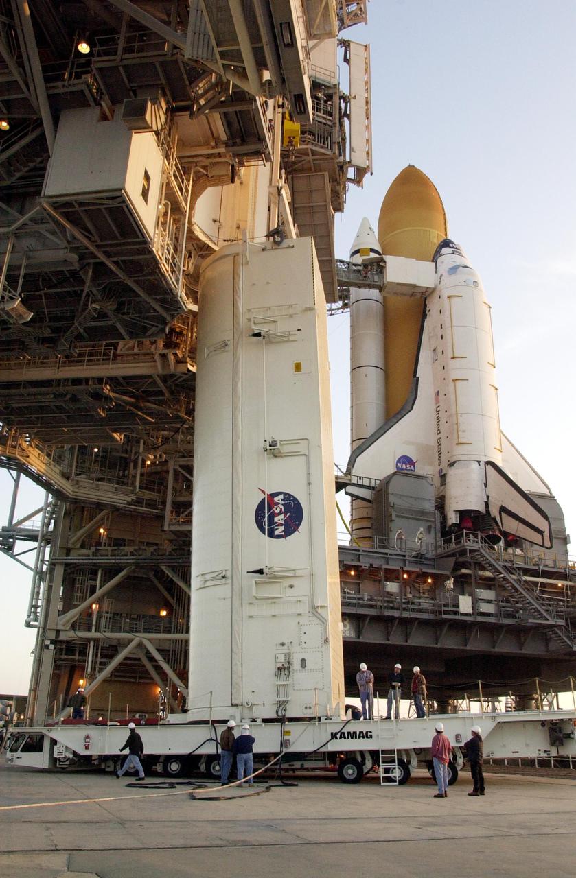 KENNEDY SPACE CENTER, FLA. - On the launch pad, workers prepare the payload canister for its lift to the payload changeout room above. Part of the payload on mission STS-110, the S0 truss will become the backbone of the orbiting International Space Station (ISS).     The S0 truss will be attached to the U.S. Lab, 'Destiny,'  on the 11-day mission.    Launch is scheduled for April 4