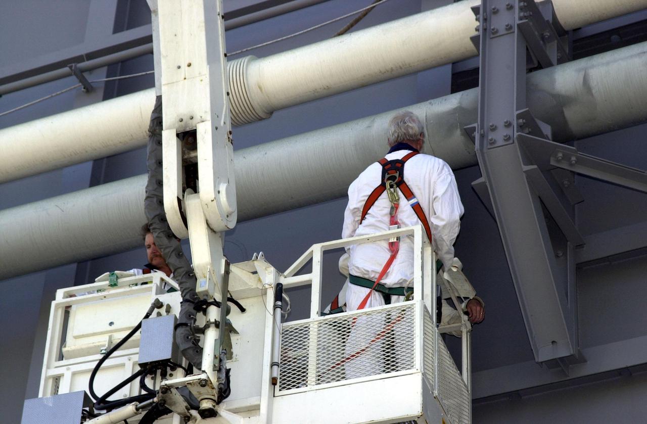 KENNEDY SPACE CENTER, FLA. -- At Launch Pad 39B, a worker on a crane inspects pipes on the Mobile Launcher Platform where Space Shuttle Atlantis sits.  Earlier today a leak in a ground support liquid hydrogen vent line on the south side of the Mobile Launcher Platform caused a scrub of the launch of Atlantis on mission STS-110. An engineering team is assessing the situation to determine the best method to repair the hydrogen line.  The turnaround plan includes time to perfor weld repairs and return the vehicle to a timeline to resume the countdown