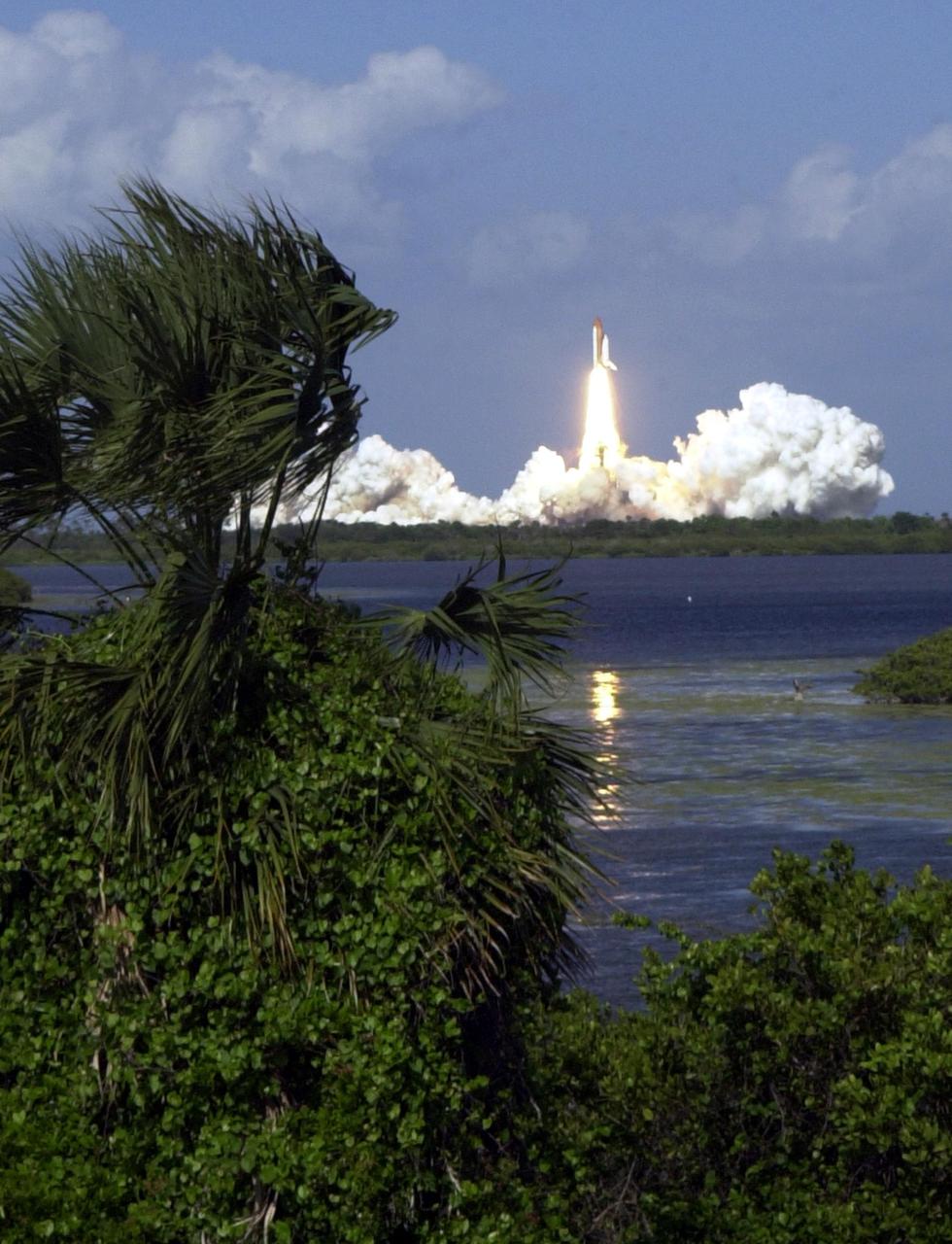 KENNEDY SPACE CENTER, FLA. -  Gusty winds that blow the palmettos in the foreground don't deter the launch of Space Shuttle Atlantis, across the water, on mission STS-110.  Liftoff occurred at 4:44:19 p.m. EDT (20:41:19 GMT). STS-110 is the 13th assembly flight to the International Space Station