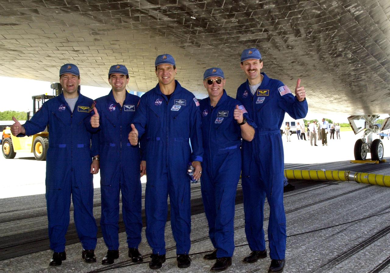 KENNEDY SPACE CENTER, FLA. - Standing underneath Atlantis, the STS-110 crew poses for a photo.  From left are Pilot Stephen Frick, Mission Specialist Rex Walheim, Commander Michael Bloomfield, and Mission Specialists Jerry Ross and Steven Smith.  The sixth and seventh crew members, Mission Specialist Ellen Ochoa and Lee Morin, are missing from the photo. Atlantis landed on KSC's Shuttle Landing Facility after 171 orbits, completing a 10-day, 19-hour, 4.5-million mile mission to the International Space Station. Main gear touchdown was 12:26:57 p.m. EDT, nose gear touchdown was 12:27:09 p.m. and wheel stop was 12:28:07 p.m.  The crew delivered and installed the S0 truss, which will support cooling and power systems essential for the addition of future international laboratories, on the Station