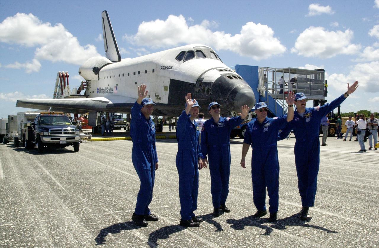 KENNEDY SPACE CENTER, FLA. - The STS-110 crew waves to spectators before leaving the Shuttle Landing Facility for crew quarters. .  From left are Commander Michael Bloomfield, Pilot Stephen Frick, and Mission Specialists Rex Walheim, Jerry Ross and Steven Smith.  Missing crew members are Mission Specialists Ellen Ochoa and Lee Morin.  Atlantis, behind them, landed on KSC's Shuttle Landing Facility after 171 orbits, completing a 10-day, 19-hour, 4.5-million mile mission to the International Space Station. Main gear touchdown was 12:26:57 p.m. EDT, nose gear touchdown was 12:27:09 p.m. and wheel stop was 12:28:07 p.m.  The crew delivered and installed the S0 truss, which will support cooling and power systems essential for the addition of future international laboratories, on the Station