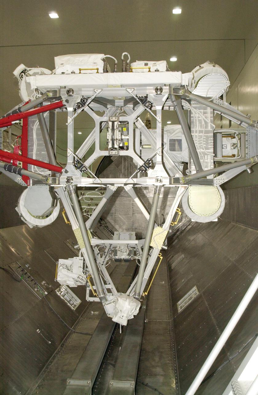 KENNEDY SPACE CENTER, FLA. - In the Space Station Processing Facility, the payload carrier with the Mobile Base System is lowered into the payload canister. On mission STS-111 to the International Space Station, the MBS will be installed on the Mobile Transporter to complete the Canadian Mobile Servicing System, or MSS. The mechanical arm will then have the capability to 'inchworm' from the U.S. Lab Destiny to the MSS and travel along the truss to work sites. STS-111 is the second utilization flight (UF-2) to the Space Station and will also carry the Expedition 5 crew to replace Expedition 4. Launch is scheduled for May 30, 2002