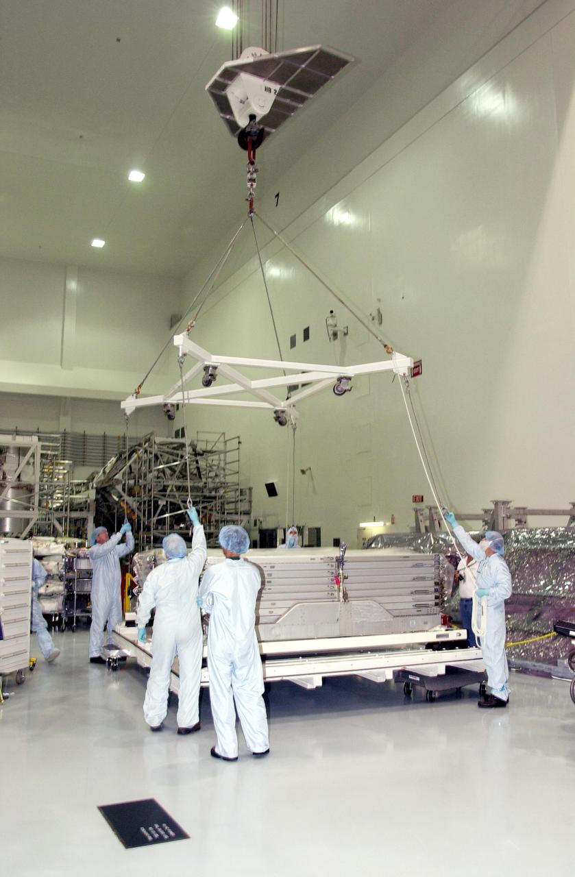KENNEDY SPACE CENTER, FLA. -- In the Space Station Processing Facility, workers prepare to attach an overhead crane to the radiator assembly that just arrived. The radiator is part of the payload on mission STS-113, which also includes the first port truss segment, P1 Truss, to be attached to the central truss segment, S0 Truss, on the International Space Station. Once delivered, the will remain stowed until flight 12A.1. STS-113 is scheduled to launch Oct. 6, 2002