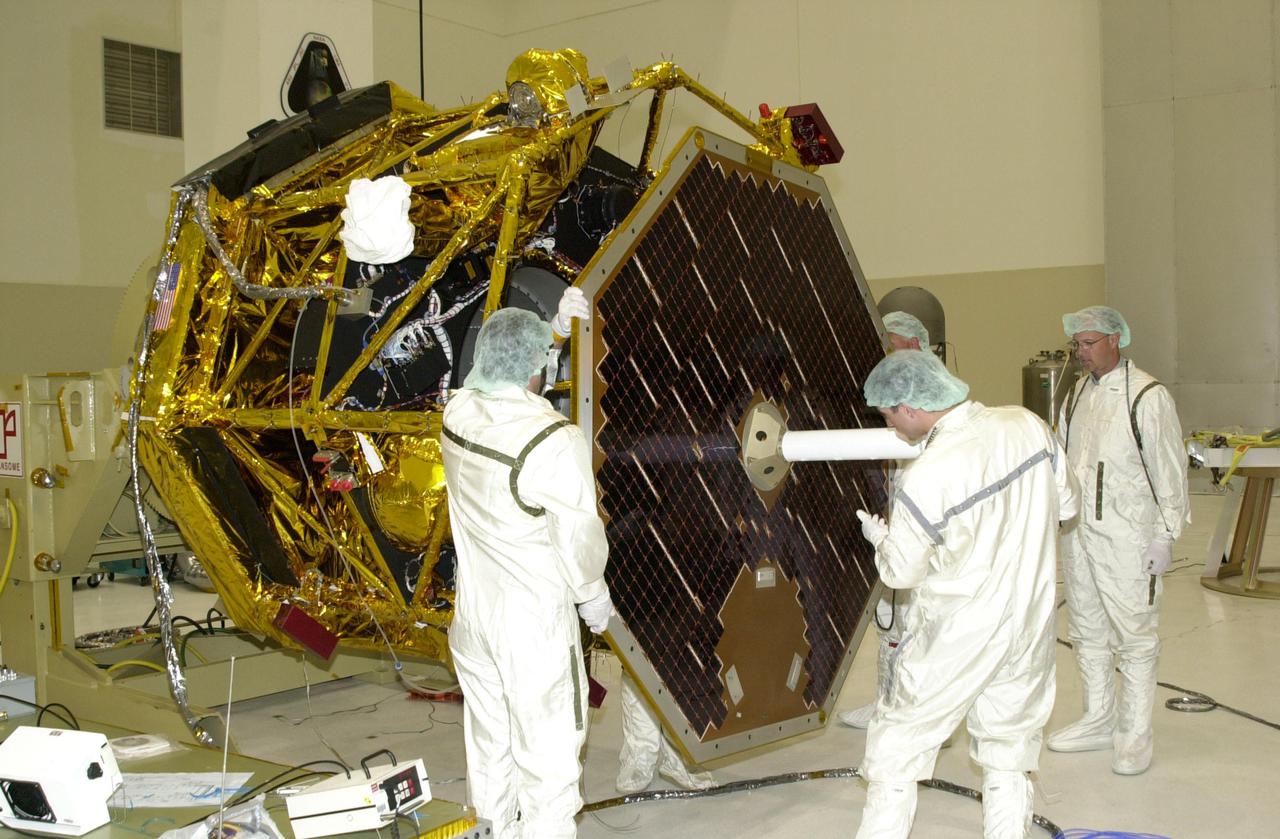 KENNEDY SPACE CENTER, FLA. -- In the Spacecraft Assembly and Encapsulation Facility 2 (SAEF-2), workers check placement of the solar panel and attached antenna before attaching it to the Comet Nucleus Tour (CONTOUR) spacecraft. Scheduled for launch July 1, 2002, from LC 17A at Cape Canaveral Air Force Station, CONTOUR will provide the first detailed look into the heart of a comet -- the nucleus. The spacecraft will fly as close as 60 miles (100 kilometers) to at least two comets, Encke and Schwassmann-Wachmann 3. It will take the sharpest pictures yet of the nucleus while analyzing the gas and dust that surround these rocky, icy building blocks of the solar system. The Applied Physics Laboratory of Johns Hopkins University, Baltimore, Md., built CONTOUR and will also be in control of the spacecraft after launch