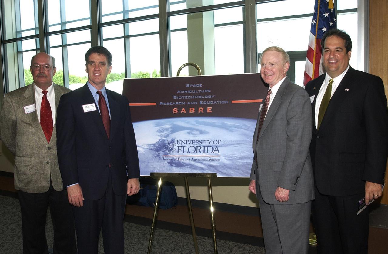 KENNEDY SPACE CENTER, FLA. --  At the opening ceremony for the new program known as SABRE, Space Agricultural Biotechnology Research and Education, four of the speakers gather around the SABRE poster.  From left are University of Florida Vice President for Agriculture and Natural Resources Mike Martin, U.S. Representative Dave Weldon, Center Director Roy D. Bridges Jr., and Florida Representative Bob Allen. Involving UF and NASA,  SABRE will focus on the discovery, development and application of the biological aspects of advanced life support strategies. The program will include faculty from UF's Institute of Food and Agricultural Sciences, who will be located at both KSC - in the state-owned Space Experiment Research and Processing Laboratory (SERPL) being built there - and UF in Gainesville. Robert Ferl, professor in the horticultural sciences department and assistant director of the University of Florida Biotechnology Program, will direct and be responsible for coordinating the research and education efforts of UF and NASA.
